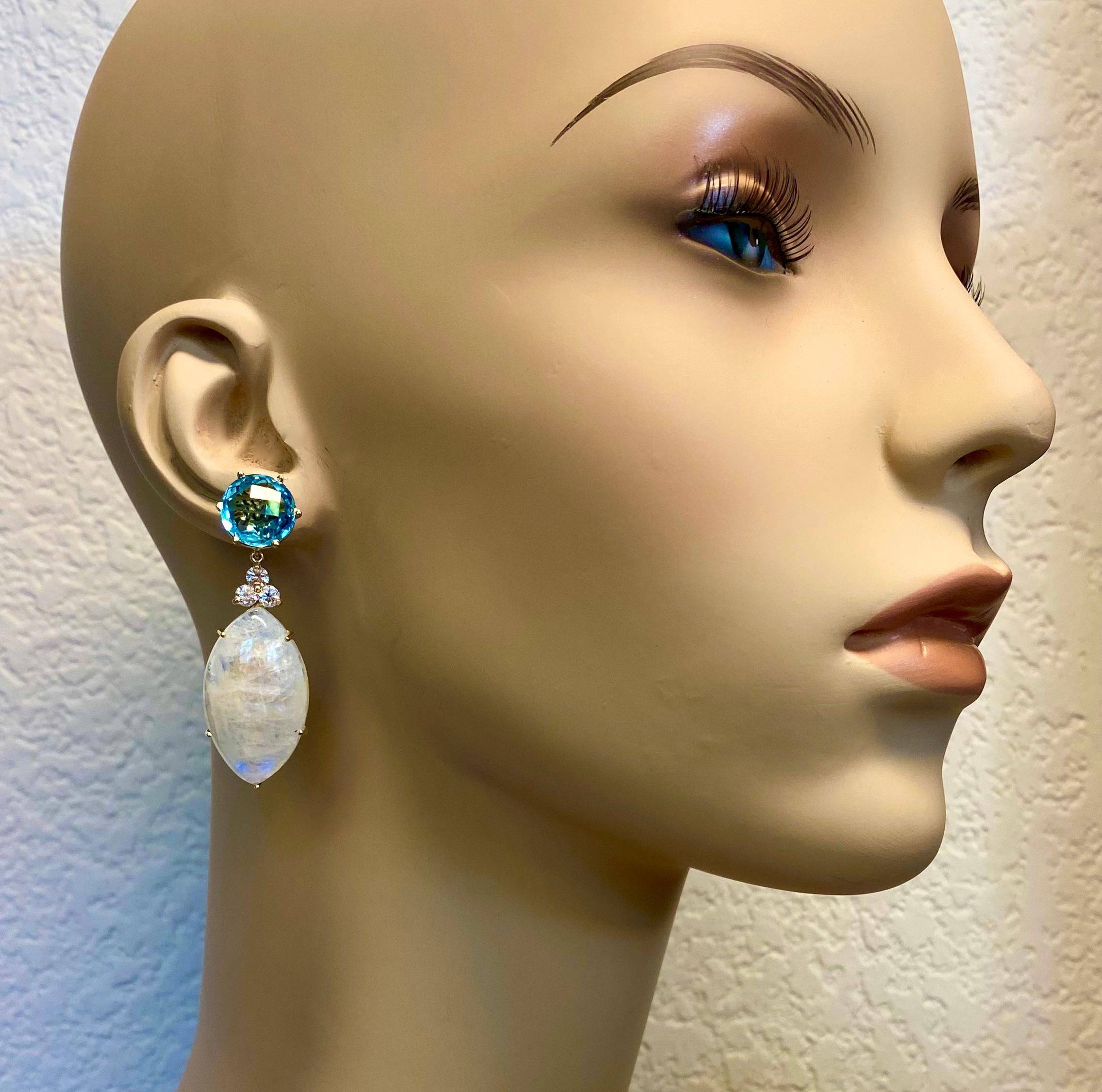 Blue flash moonstones are featured in these dynamic dangle earrings.  The moonstones (origin: Sri Lanka) are members of the feldspar family of gems which include amazonite, labradorite and sunstone.  The navette shaped and custom-cut gems have