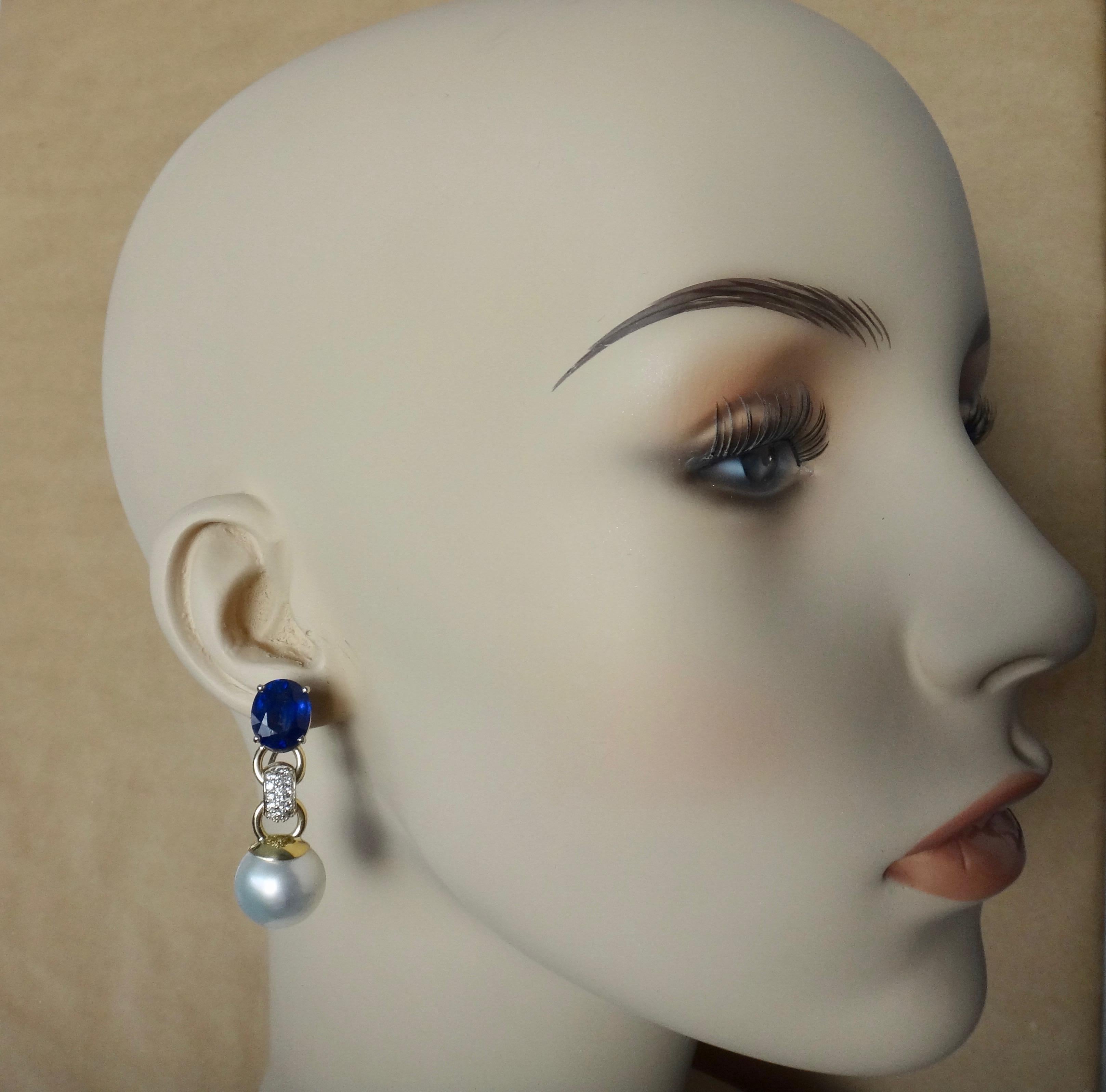Blue sapphires (origin: Thailand) are paired with slightly baroque, gem quality Paspaley South Seas pearls in these classic dangle earrings.  The sapphires are royal blue in color, well cut and polished.   Tying the two design elements together are