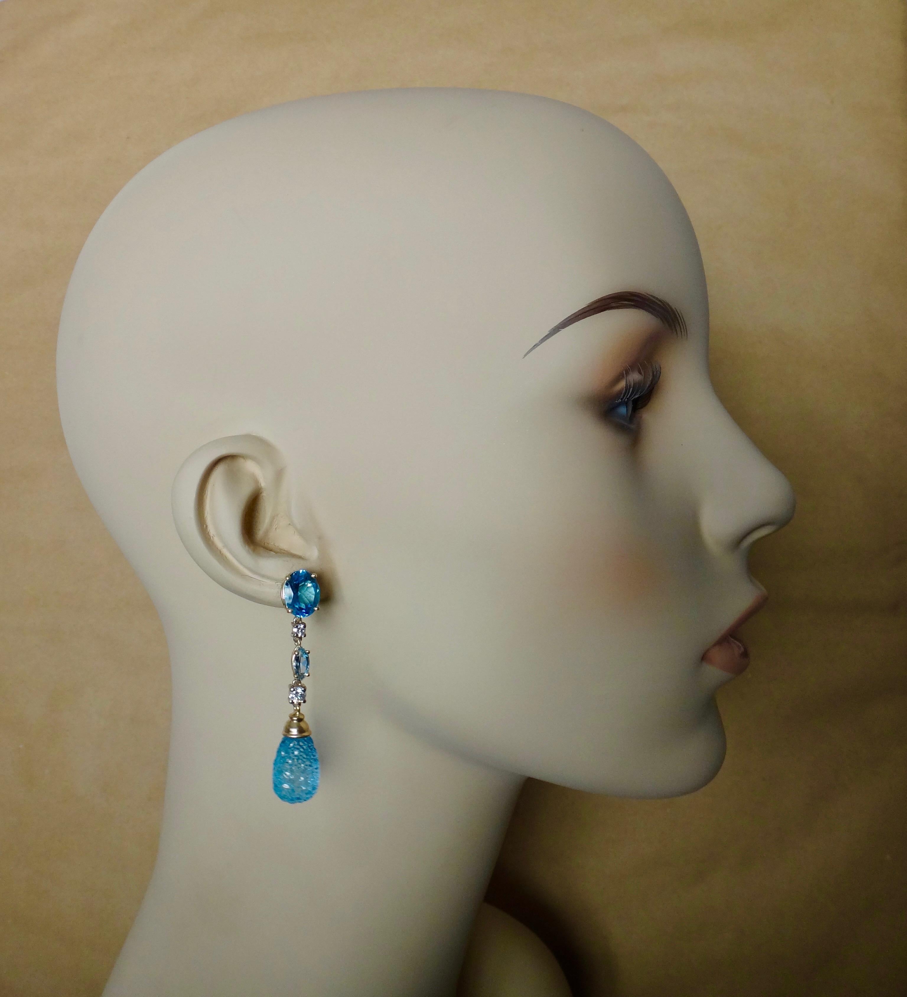 Blue topaz briolette are carved in highly unusual honeycomb patterns in these ravishing dangle earrings.  Included in the composition are oval shaped and faceted blue topaz together with marquise cut aquamarines and white diamonds.  All the gems are