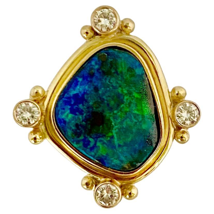 Boulder opal forms the centerpiece of this archaic style ring.  Boulder opal (origin: Queensland, Australia) forms in crevices of matrix rock-thus the name.  This example shows brilliant blues and greens with some mother rock showing as well.  The