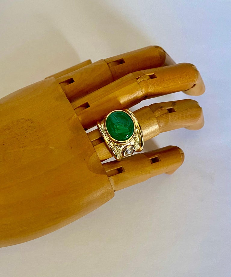 A cabochon emerald is featured in this elegant Bombe ring.  The emerald (origin: Zambia) is a brilliant 