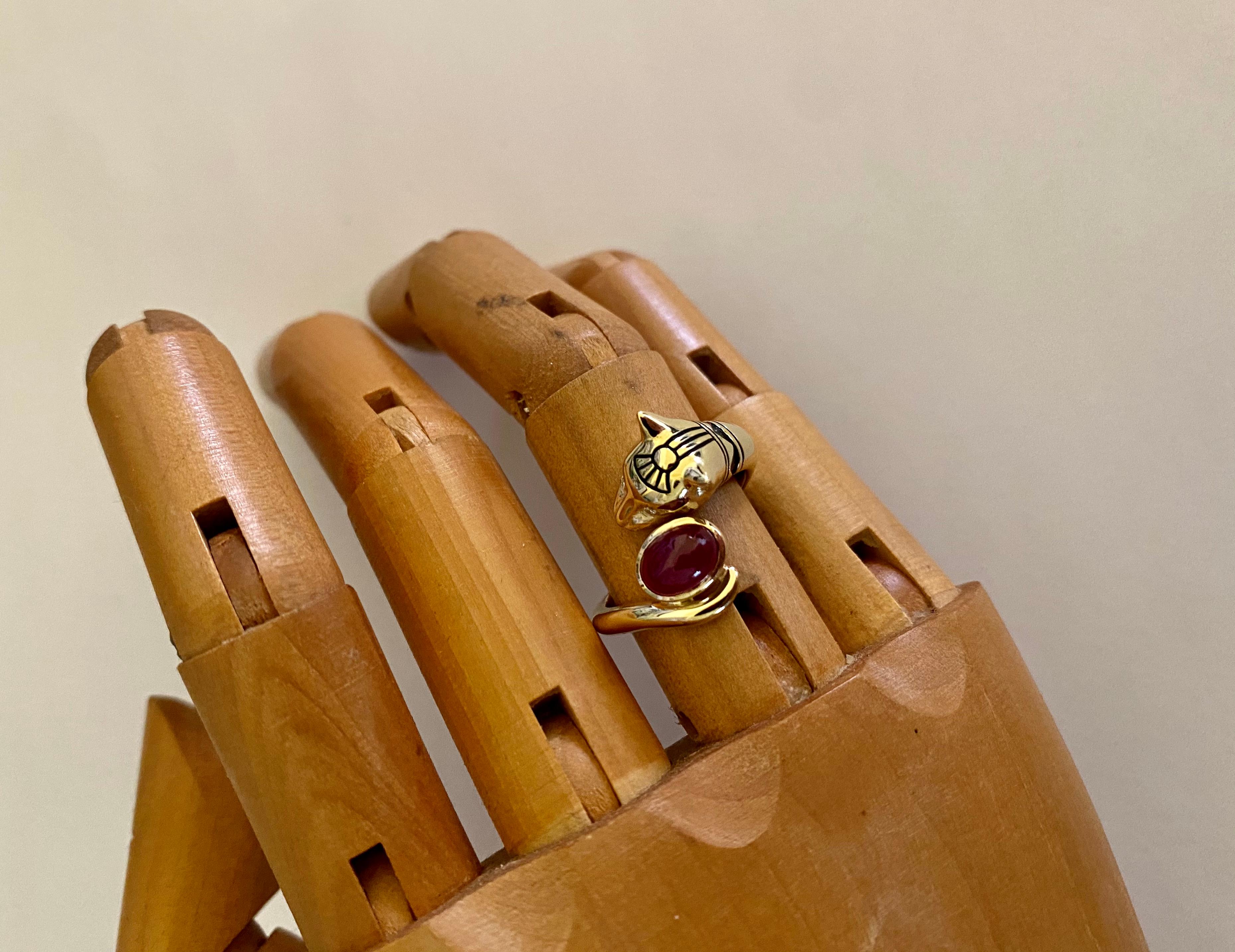 Ruby and diamonds give prominence to this Egyptian Revival cat ring.  Bastet, also known as Bast, is the fierce ancient Egyptian goddess worshiped in the form of a lion and later, after its domestication, a cat. This 18k yellow gold wearable