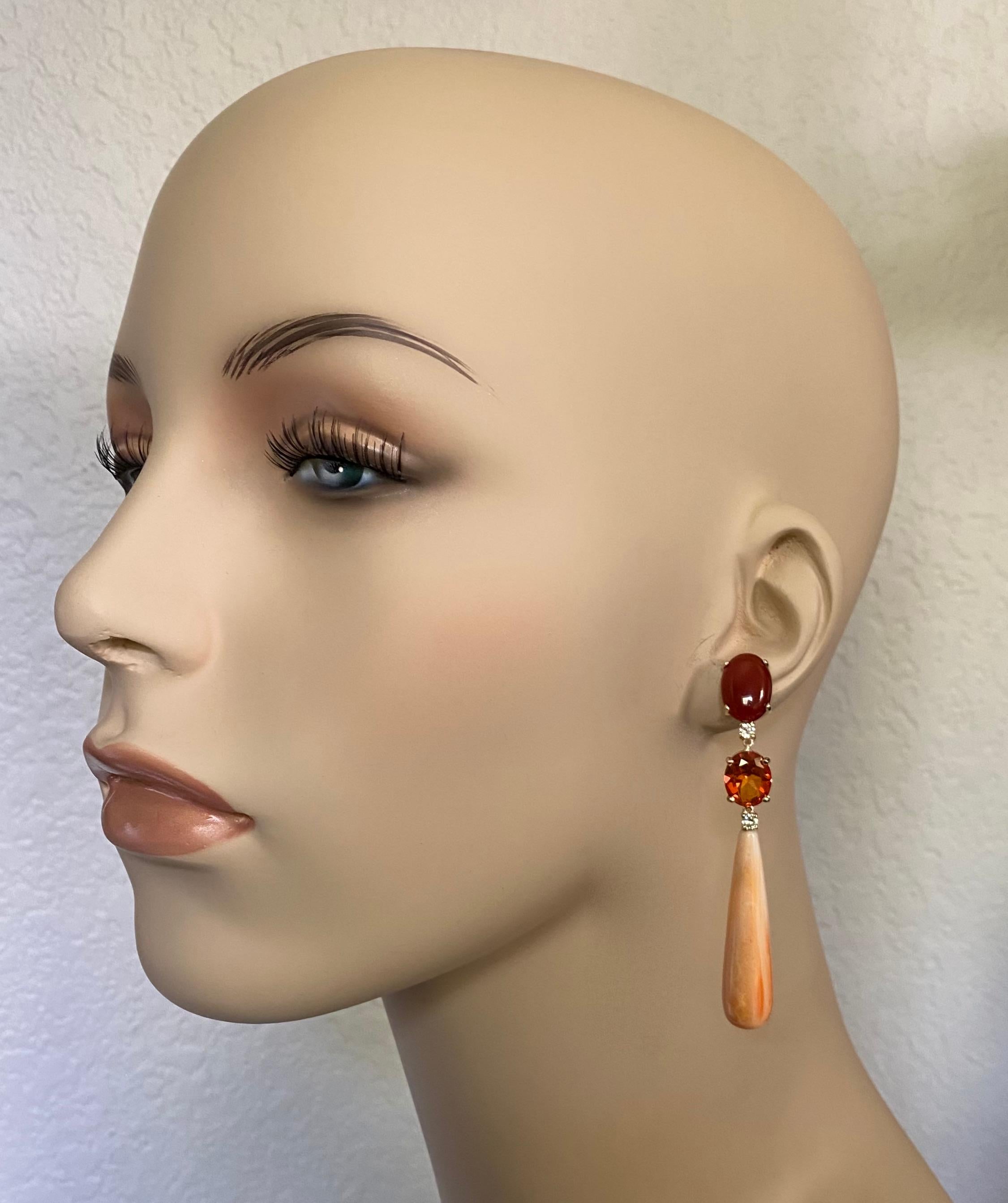 Gems in a monochromatic orange palette are used in these enchanting dangle earrings.  Cabochon cut carnelian and faceted, intensely colored Mexican fire opal are paired to compliment the highly unusual Spiny Oyster Shell drops.  All the gems are