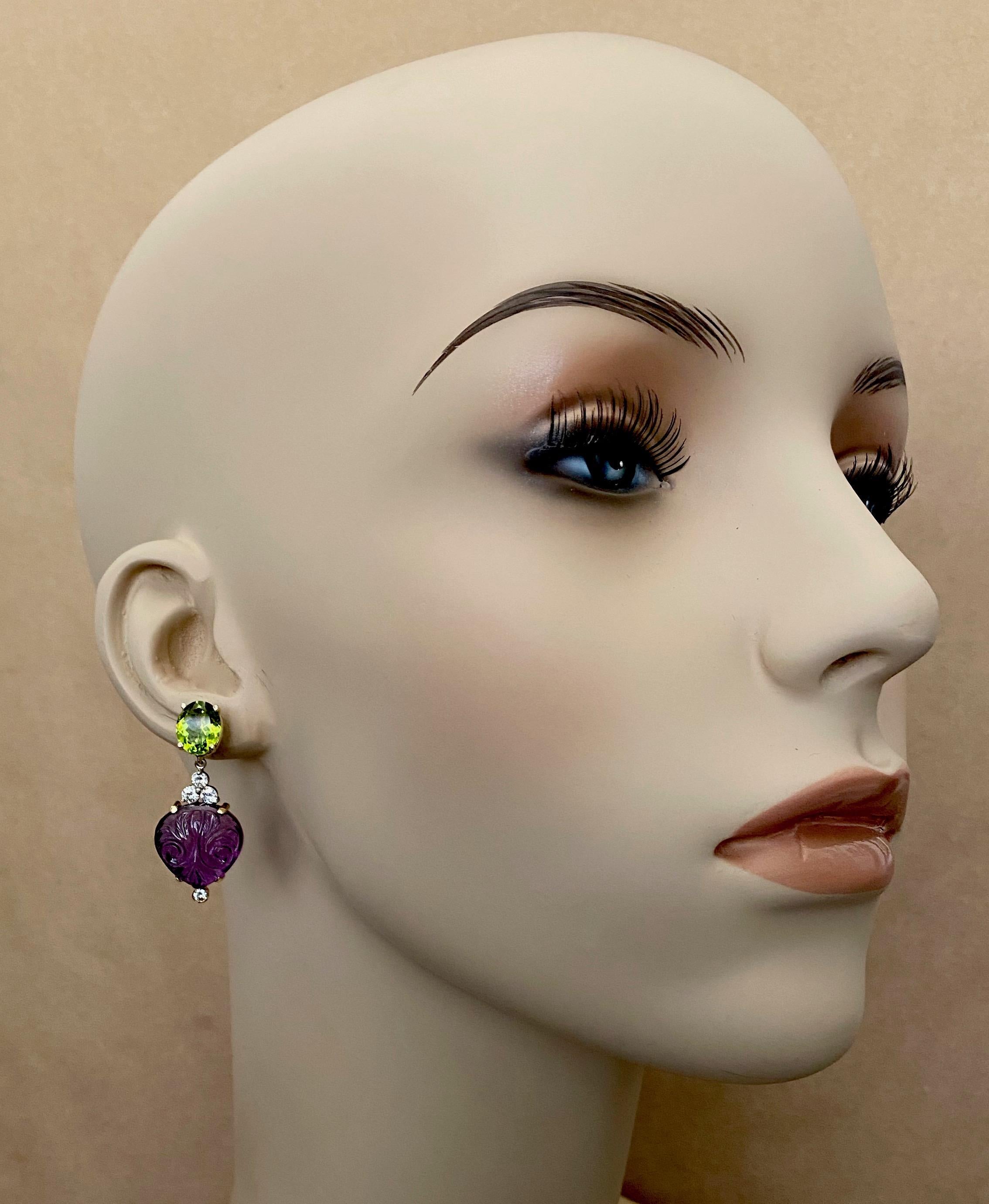 Drop shaped amethyst, carved in the classic Indian style are featured in these opulent dangle earrings.  The gems are rich purple and are expertly carved and finished.  The amethyst are complimented by oval cut peridot which are bright green, and