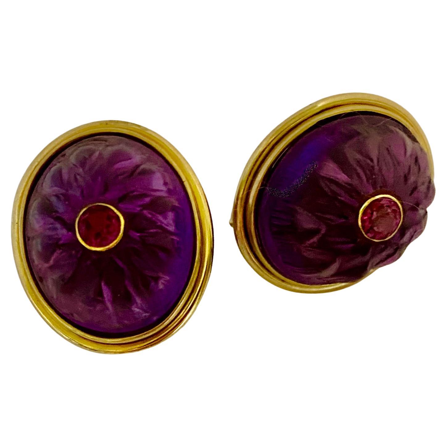 Cabochon amethyst carved in the form of stylized lotus blooms are features in these elegant button earrings.  The richly colored amethyst cabs (origin: Brazil) were carved in Indonesia.  Set within the carvings are bezel set and brilliant cut