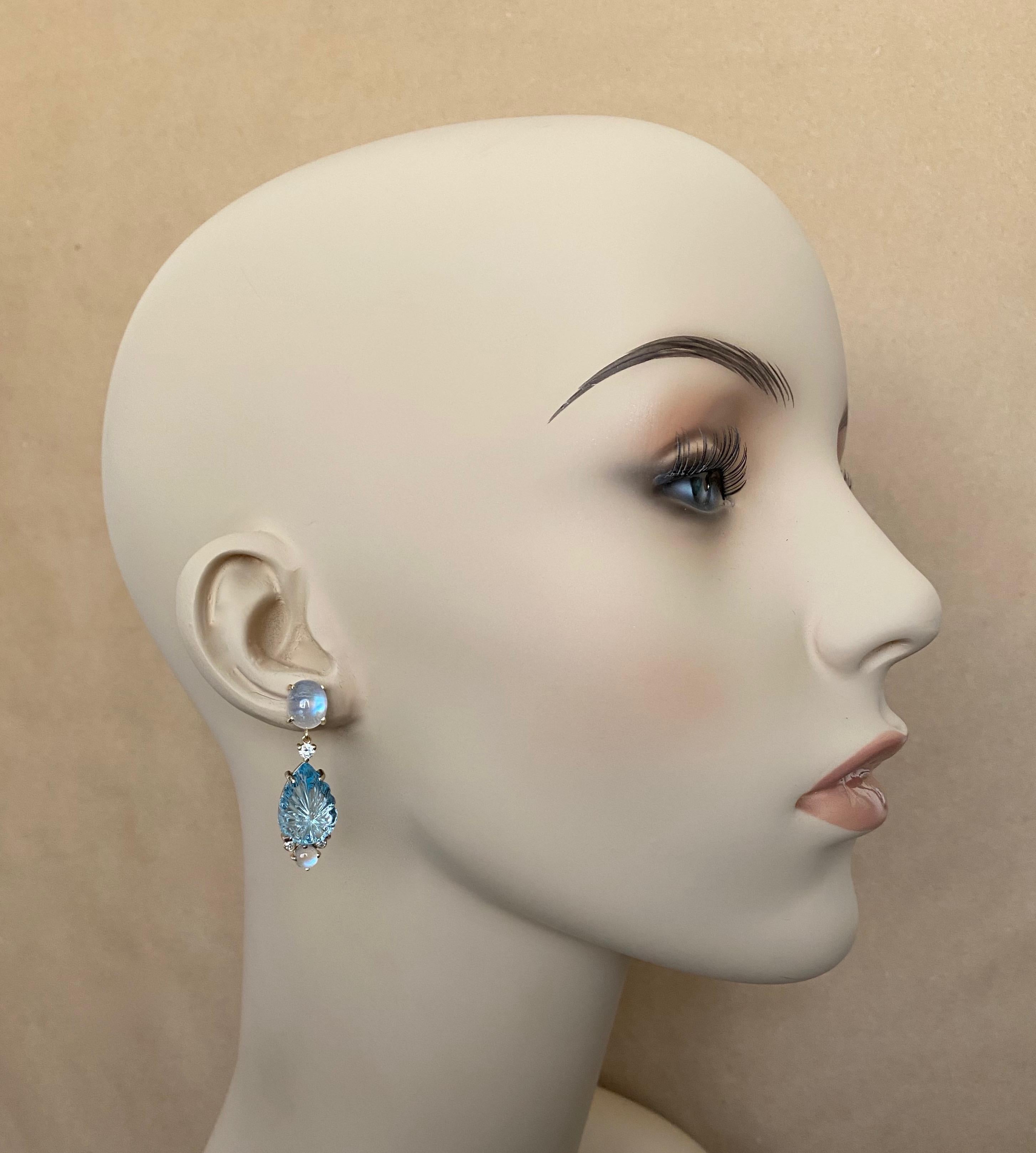 Carved sky blue topaz are featured in these ethereal dangle earrings.  The gems are carved in a starburst pattern, are expertly polished and are inclusion free.  The delicate tone of the topaz is complimented by blue flash moonstones (origin: Sri