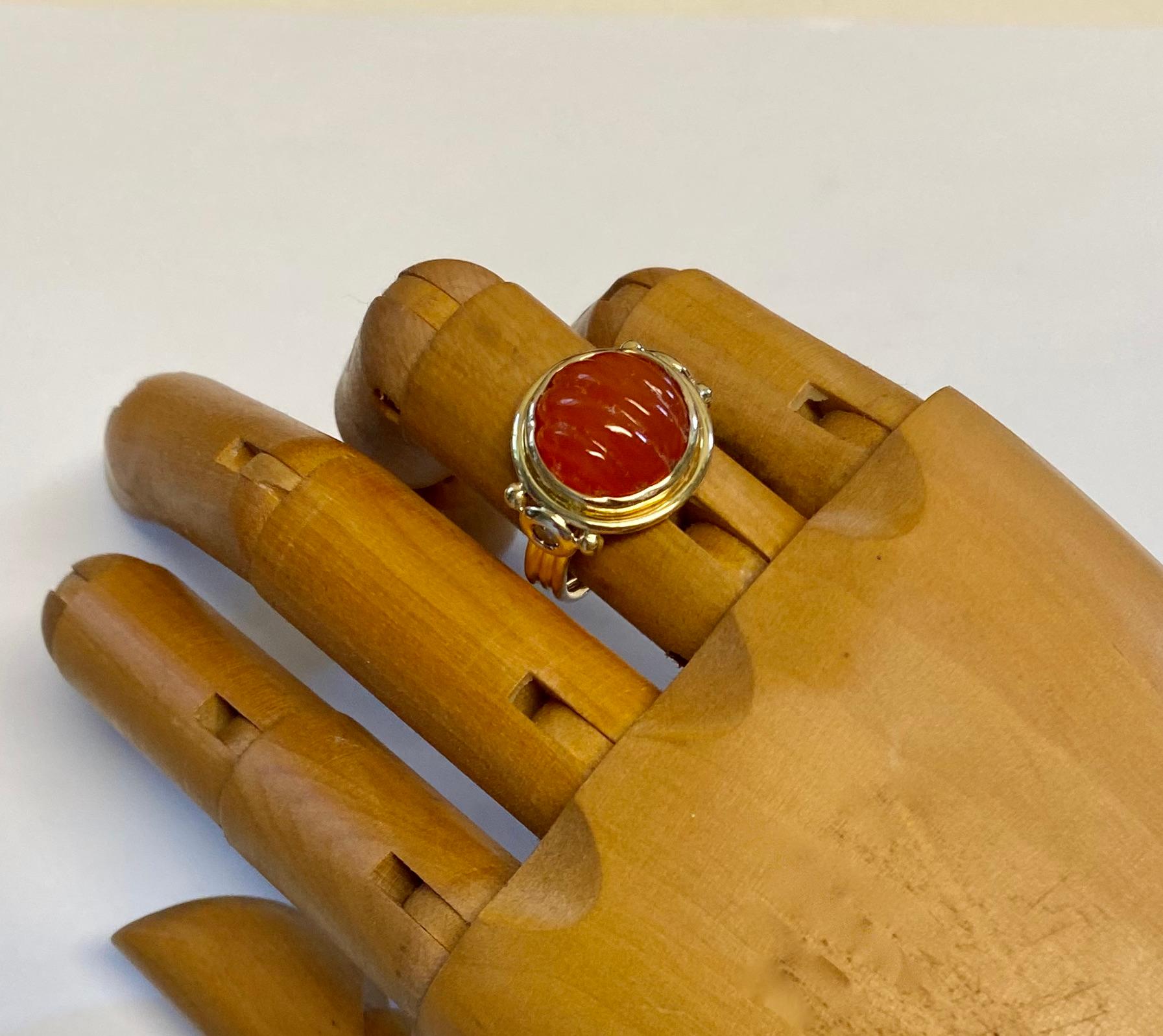 Carved carnelian is featured in this archaic style ring.  The carnelian (origin: Brazil) is a brilliant 