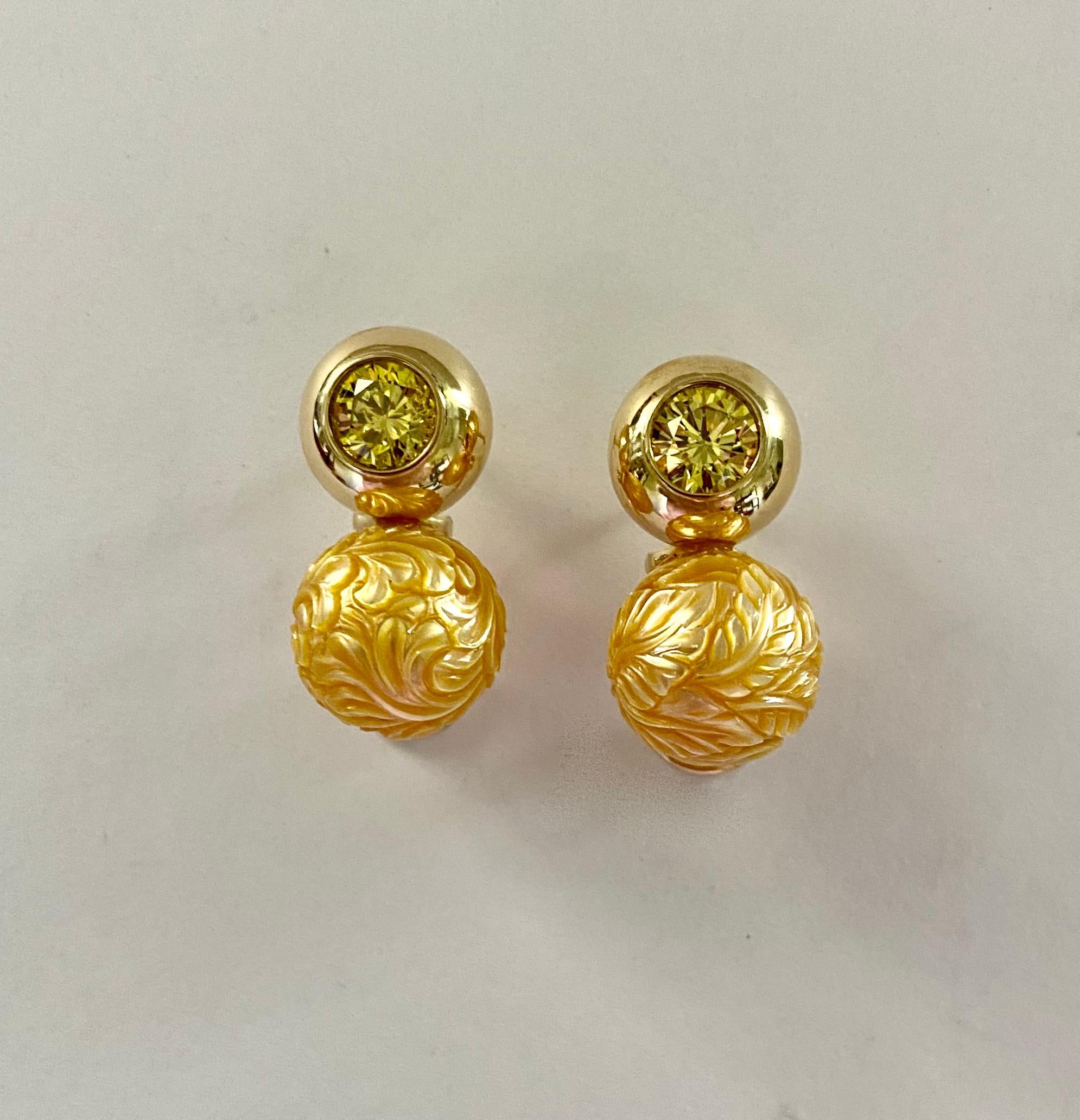Carved golden South Seas pearls are paired with yellow sapphires in the these earrings perfect for the discerning jewelry collector.  The 12.5mm buttery yellow pearls (origin: Australia) were expertly carved in Bali.  The lively, perfectly matched