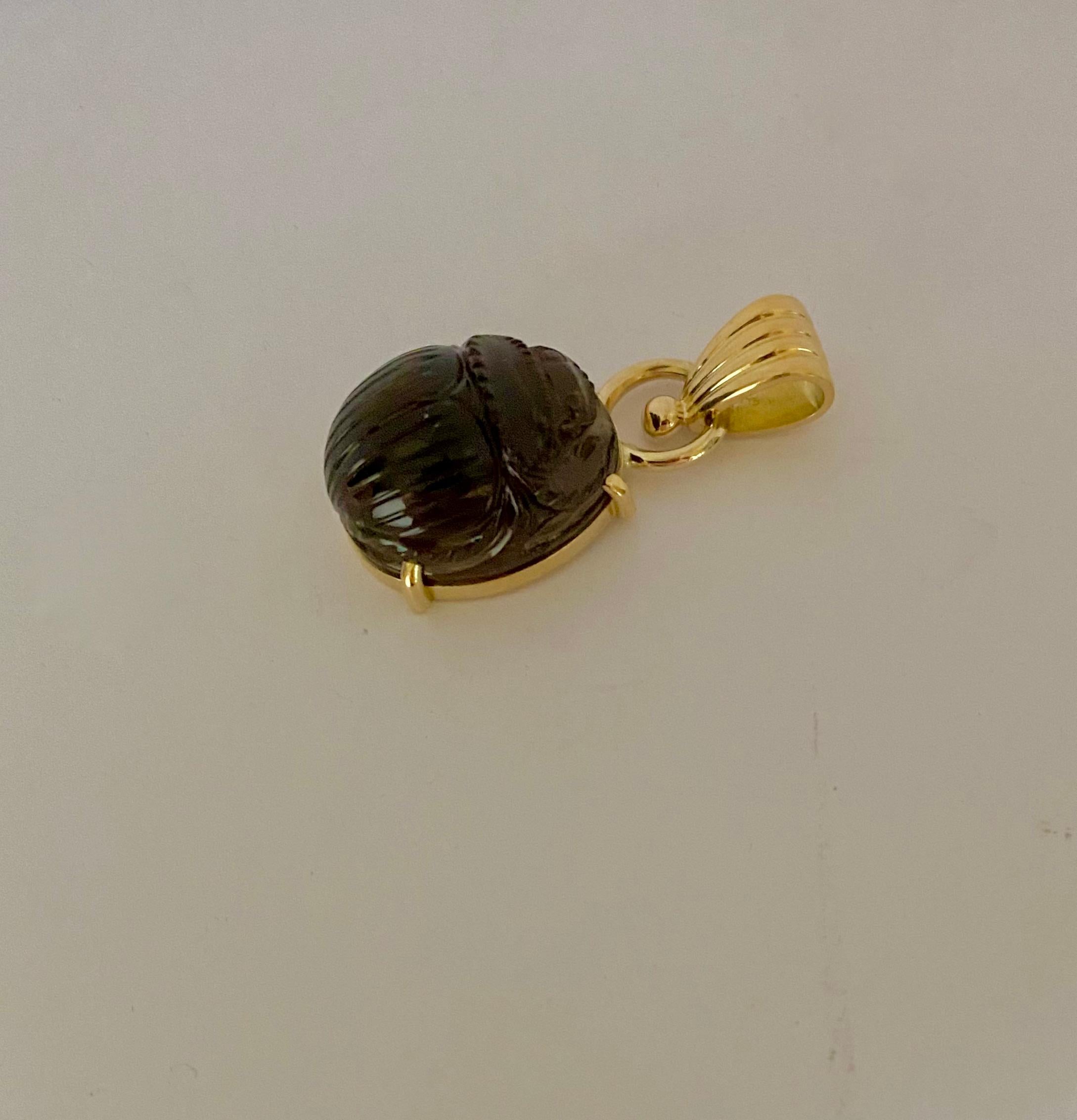 Set as a pendant is this carved smokey quartz scarab.  The richly colored quartz is exceptionally well carved.  The one-of-a-kind, modern scarab is set within an 18k gold pendant.  The bail is large and will   accommodate a variety of chains.  (The