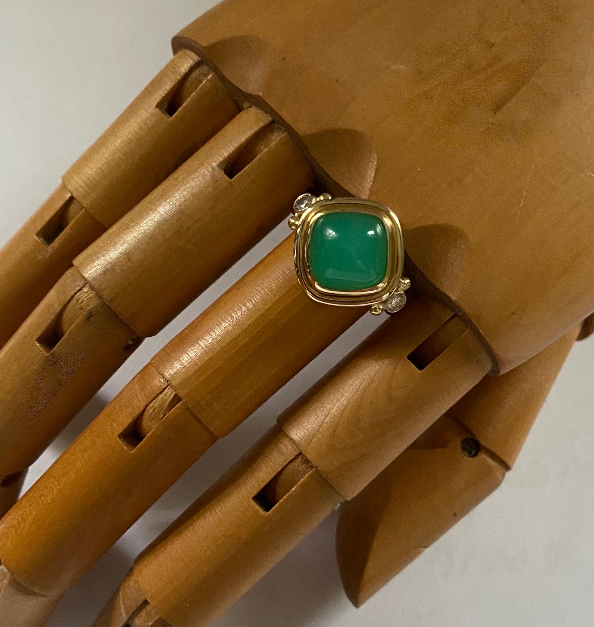 Gem quality chrysoprase is featured in this archaic style ring.  The chrysoprase (origin: Australia) is a rich apple green color and has been expertly cut into a sugarloaf cabochon shape.  The gem is bezel set and flanked by 2 white diamonds. 