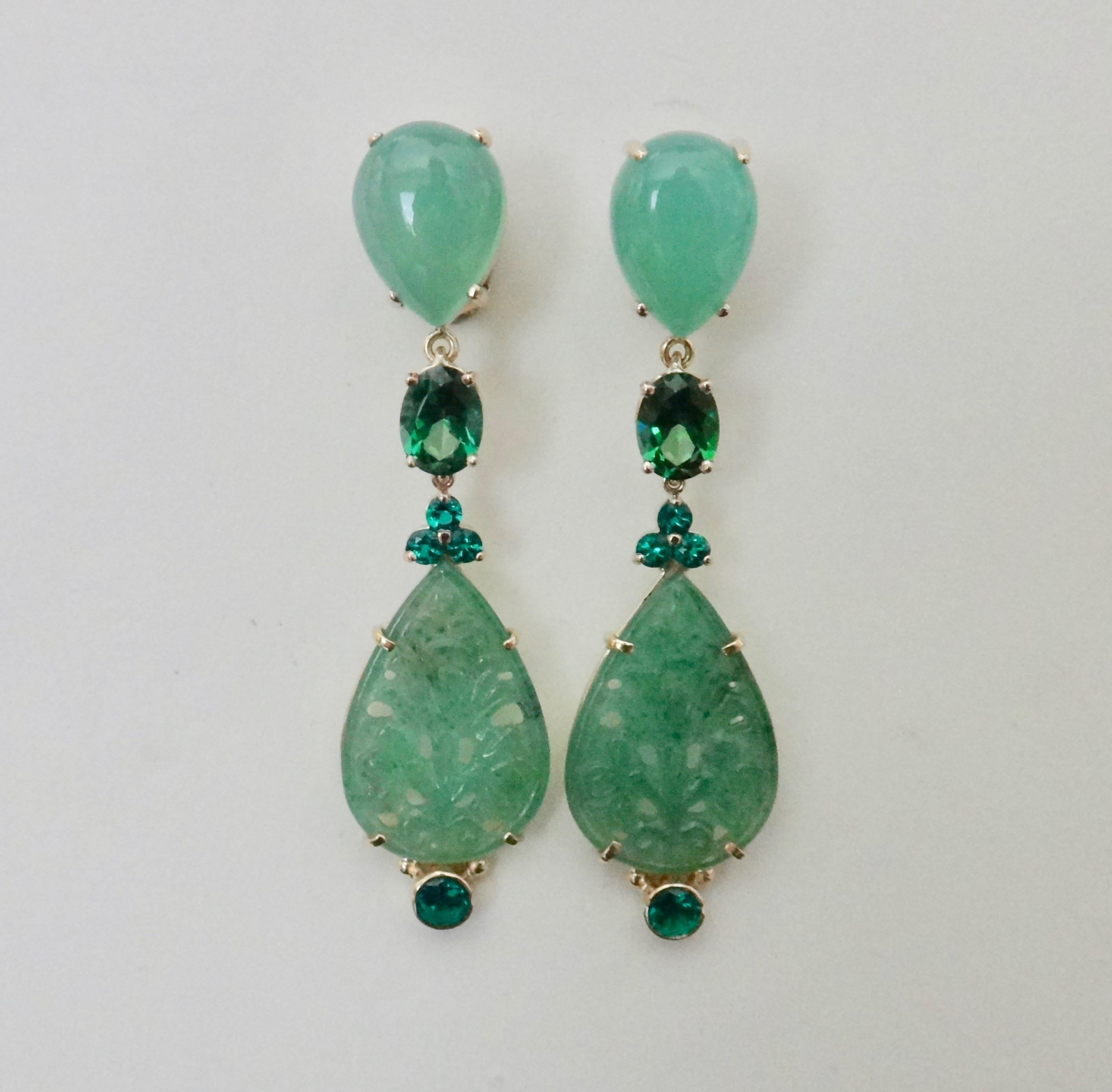 A monochromatic color scheme of greens comprise these dangle earrings.  The composition begins with pear shaped cabochon chrysoprase (origin: Australia), followed by green topaz, chrome diopside (origin: India) and finally, pale green carved