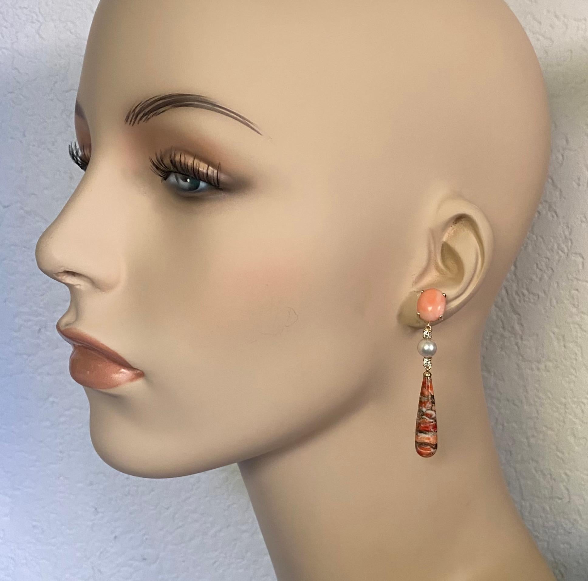 A melange of gemstones combine to form these dramatic dangle earrings.  Intensely colored pink coral (origin: Indonesia) compliments the lighter tones of the fossilized coral drops.  The pink coral cabochons are well cut, matched and polished.  The