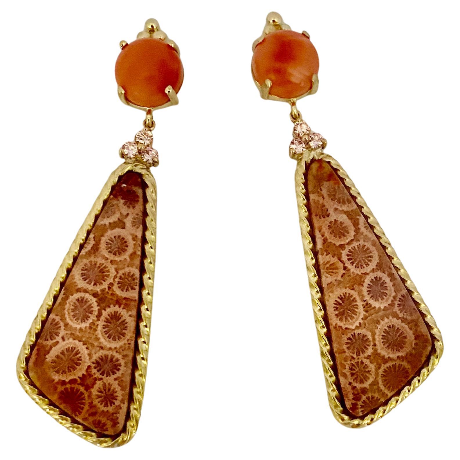 Coral is the primary gem in these dramatic dangle earrings.  The round cabochons (origin: Indonesia) are an intense salmon color and possess a glass-like polish.  They compliment the perfectly matched, fancy shaped agatized fossil coral cabochons