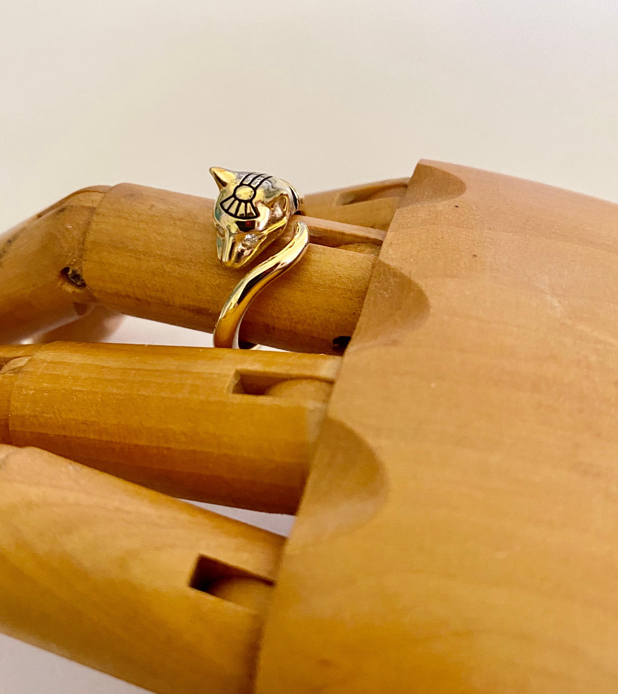 Egyptian Revival cat ring.  Bastet, also known a Bast, is the fierce Egyptian goddess worshiped in the form of a lion and later, after its domestication, a cat.  This 18k yellow gold wearable sculpture has diamond eyes.  The engraving is highlighted