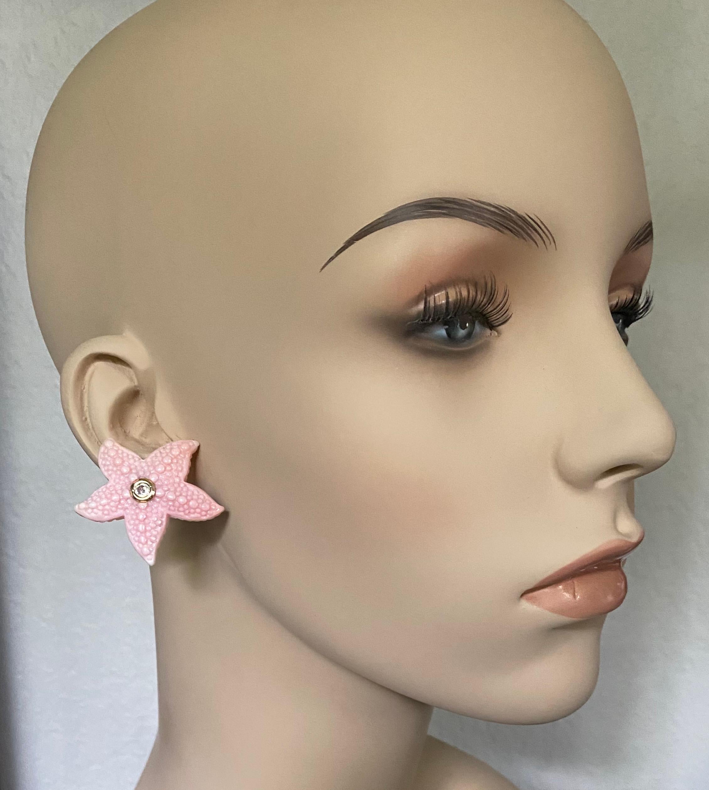 Carved Queen Conch Shell starfish are decorated with diamonds in these whimsical button earrings.  The carvings are expertly executed with exceptional detail.  Mounted in the center of each starfish is a bezel set white diamond.  These one-of-a-kind