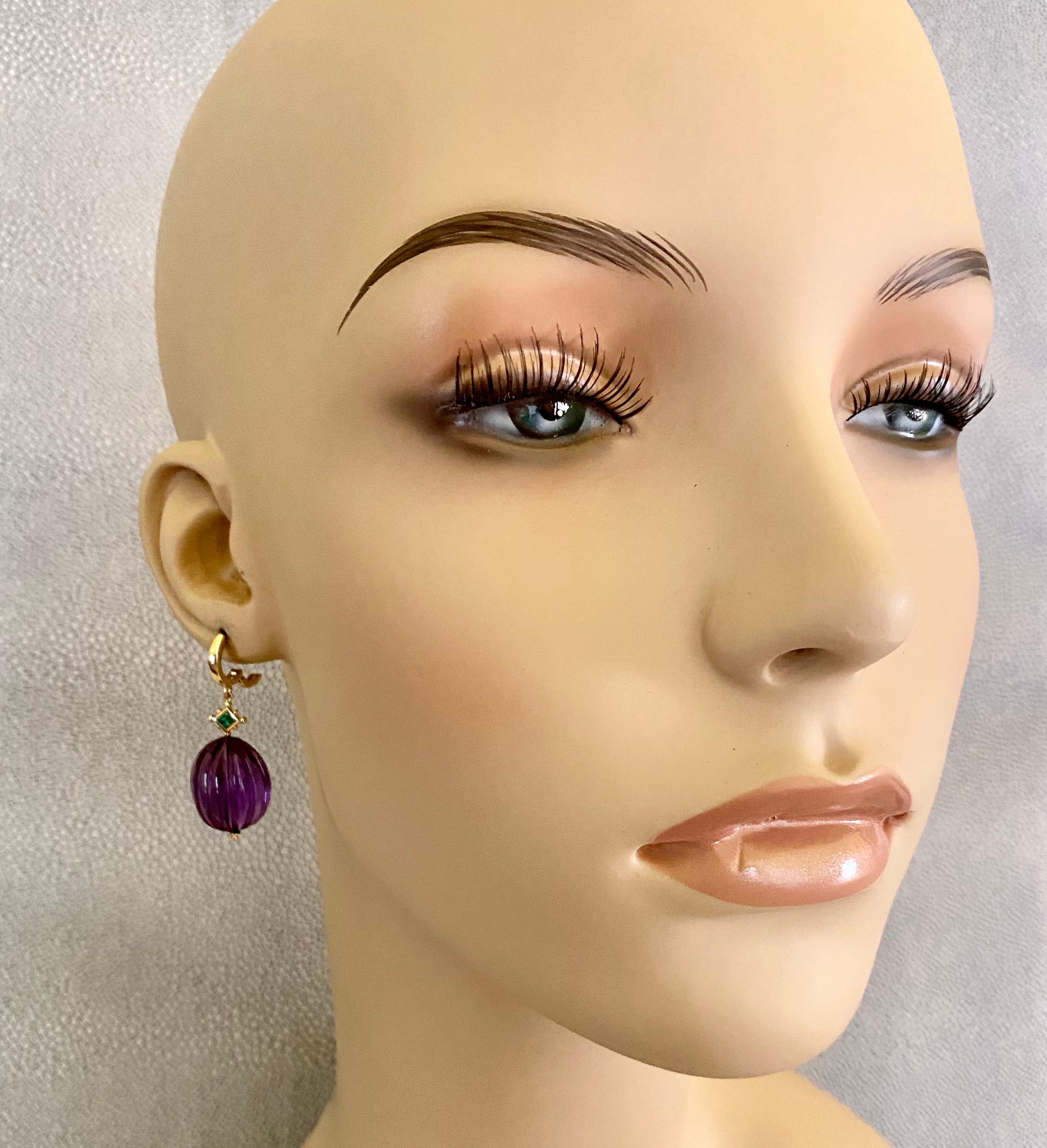 Amethyst are paired with emeralds in these elegant dangle earrings.  The amethyst (origin: Brazil) are expertly carved and polished which only enhances the natural beauty of the raw material.  The emeralds (origin: Columbia) possess exceptional