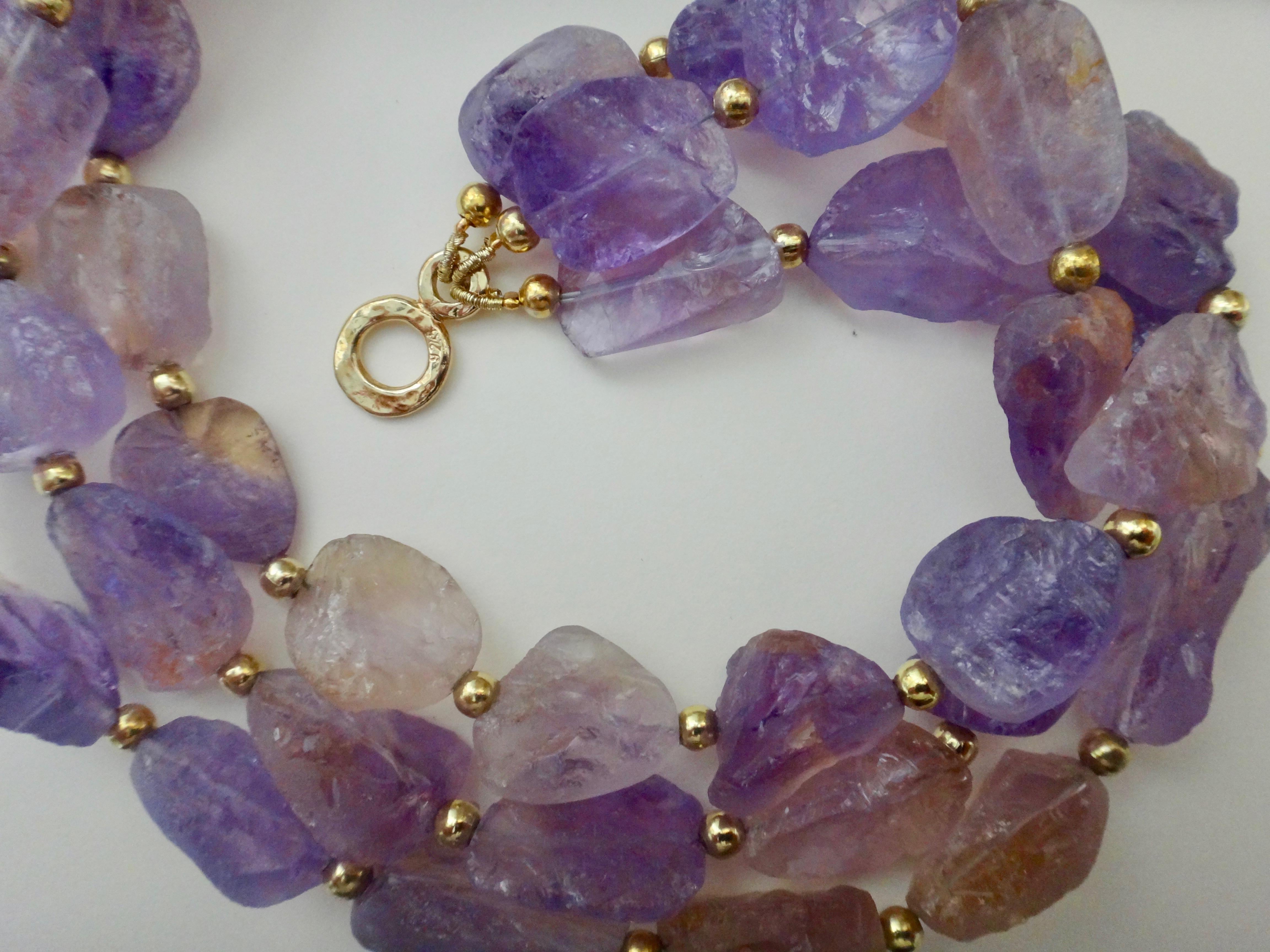 Offered here is a three strand ametrine (origin: Bolivia) torsade necklace.  Ametrine refers to the fact that both amethyst and citrine appear side by side in the same stone.  The beads were created in a process called 