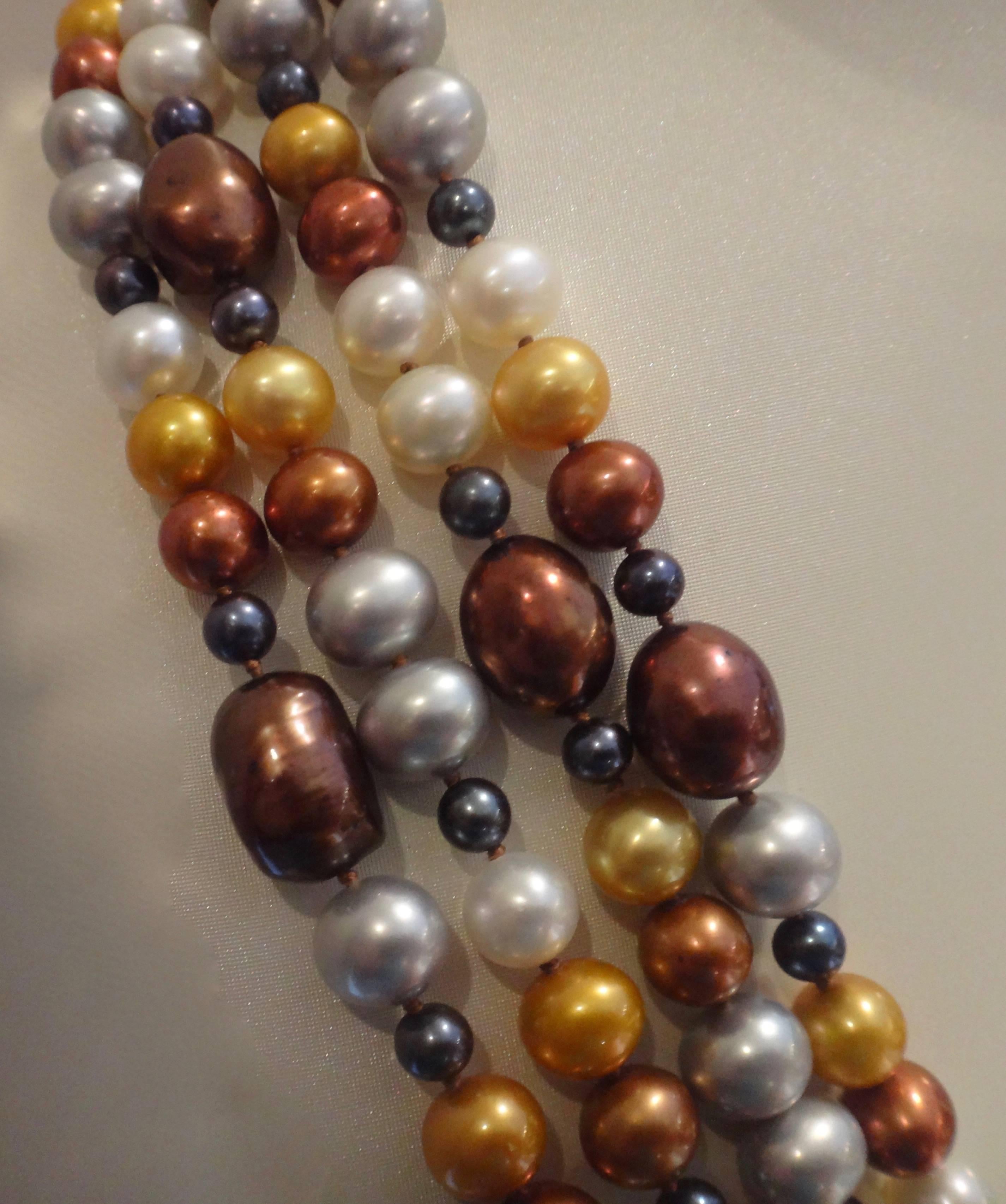 Pearls in baroque shapes and shades of bronze, copper, gold, yellow, white and black are knotted together into this dramatic four strand necklace.  The necklace is finished with a yellow gold slide clasp.  The necklace is 28 inches long.  PLEASE