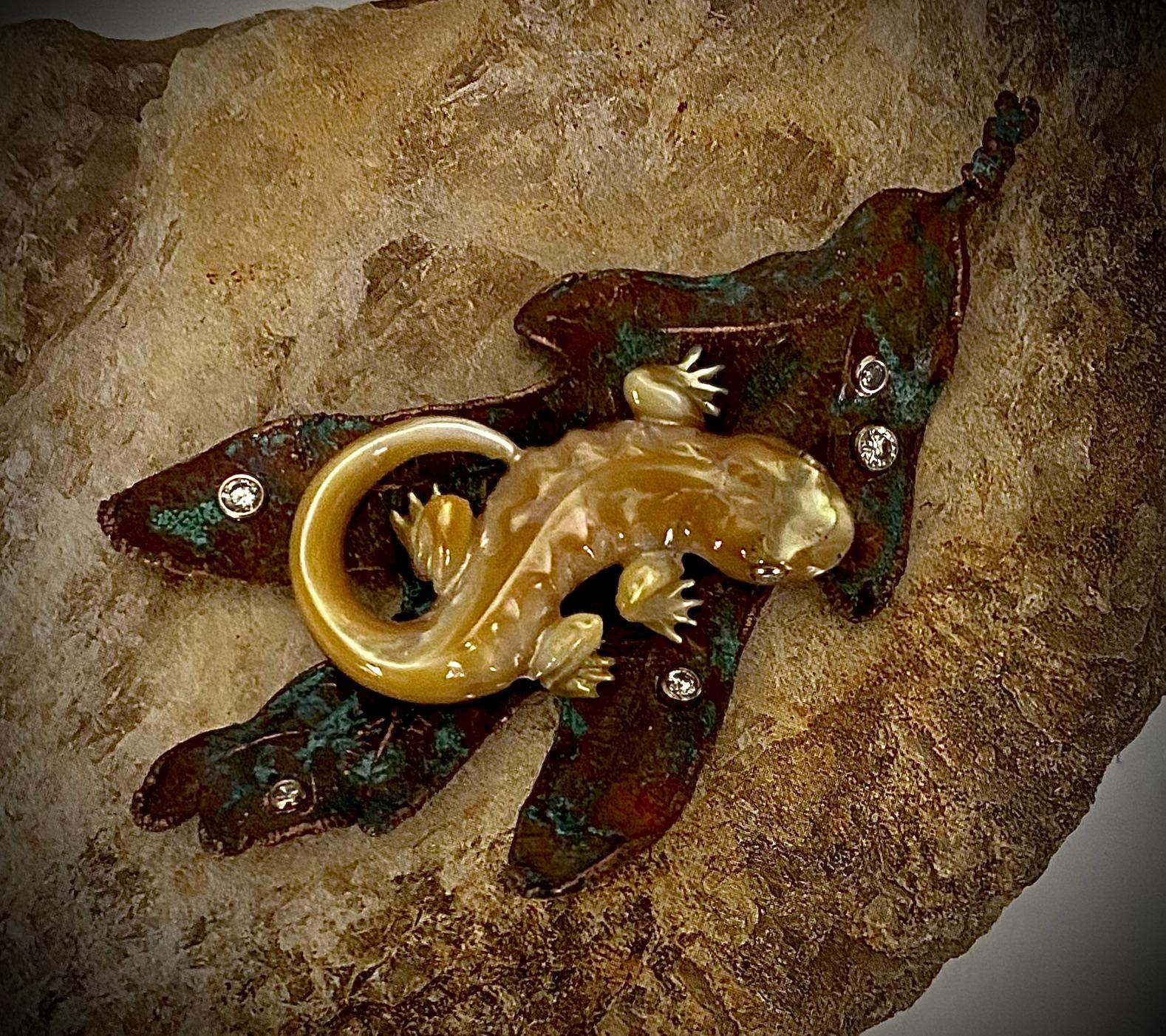 Offered for sale is this whimsical Salamander on an Oak Leaf brooch.  The amphibian is exquisitely carved in Indonesia from golden South Seas oyster shell.  The salamander has inlayed diamonds eyes reminiscent of the gemstone animals created by the