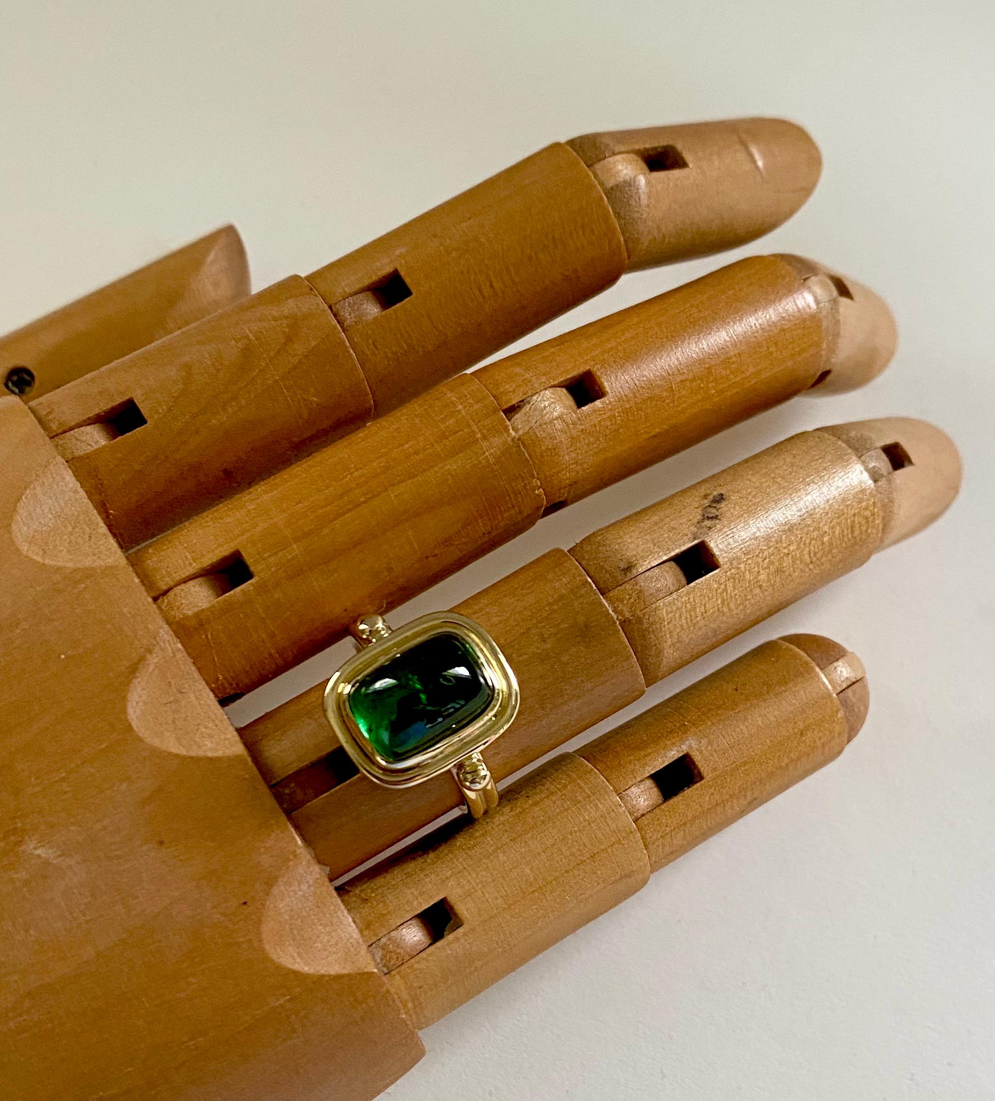 Dieser archaische Ring ist mit einem leuchtend grünen Turmalin besetzt.  Der Turmalin (ursprünglich: Brasilien) ist fachmännisch geschliffen und poliert in einer Zuckerhut-Cabochon-Form.  Der Edelstein ist in eine Lünette im archaischen Stil
