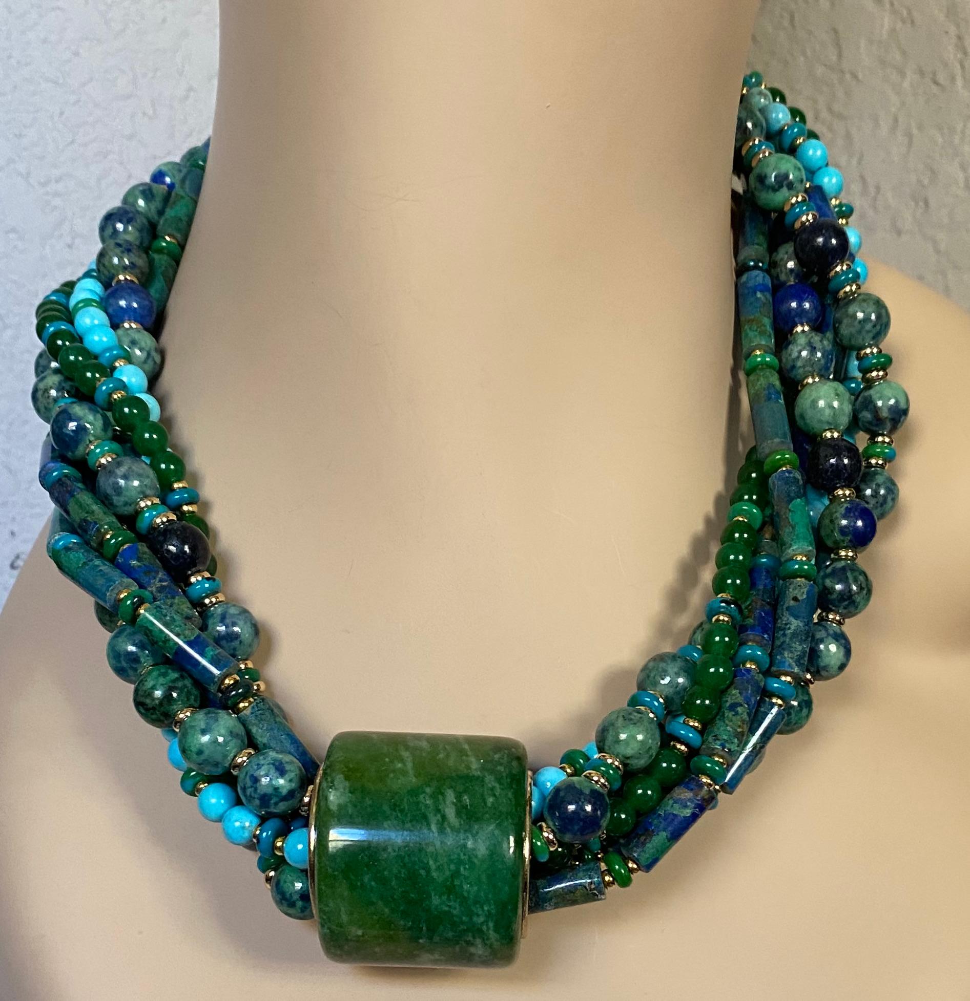 L'anello degli arcieri in giadeite è protagonista di questa dinamica collana a torsione.  La giadeite è di un ricco verde smeraldo modellato.  È ben formata e lucida.  L'anello è impreziosito da cerchi in oro giallo 18k.  L'anello scivola su una
