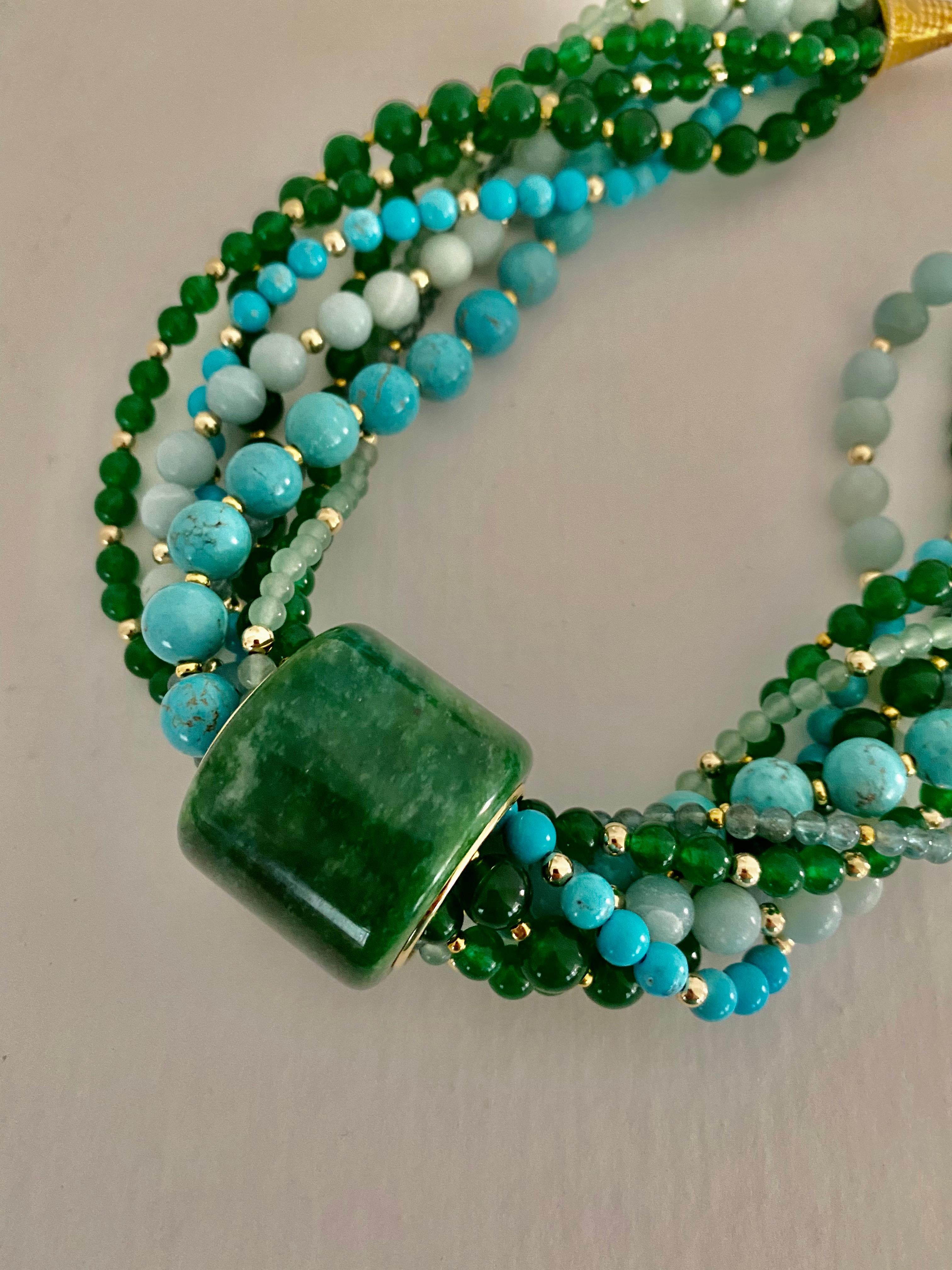 A Jadeite Archer's ring is the centerpiece of this multi-gemstone bead torsade necklace.  Jadeite (origin: Myanmar) is the supreme member of the larger jade family.  It is valued for its range of colors, hardness and durability.  Jadeite polishes to