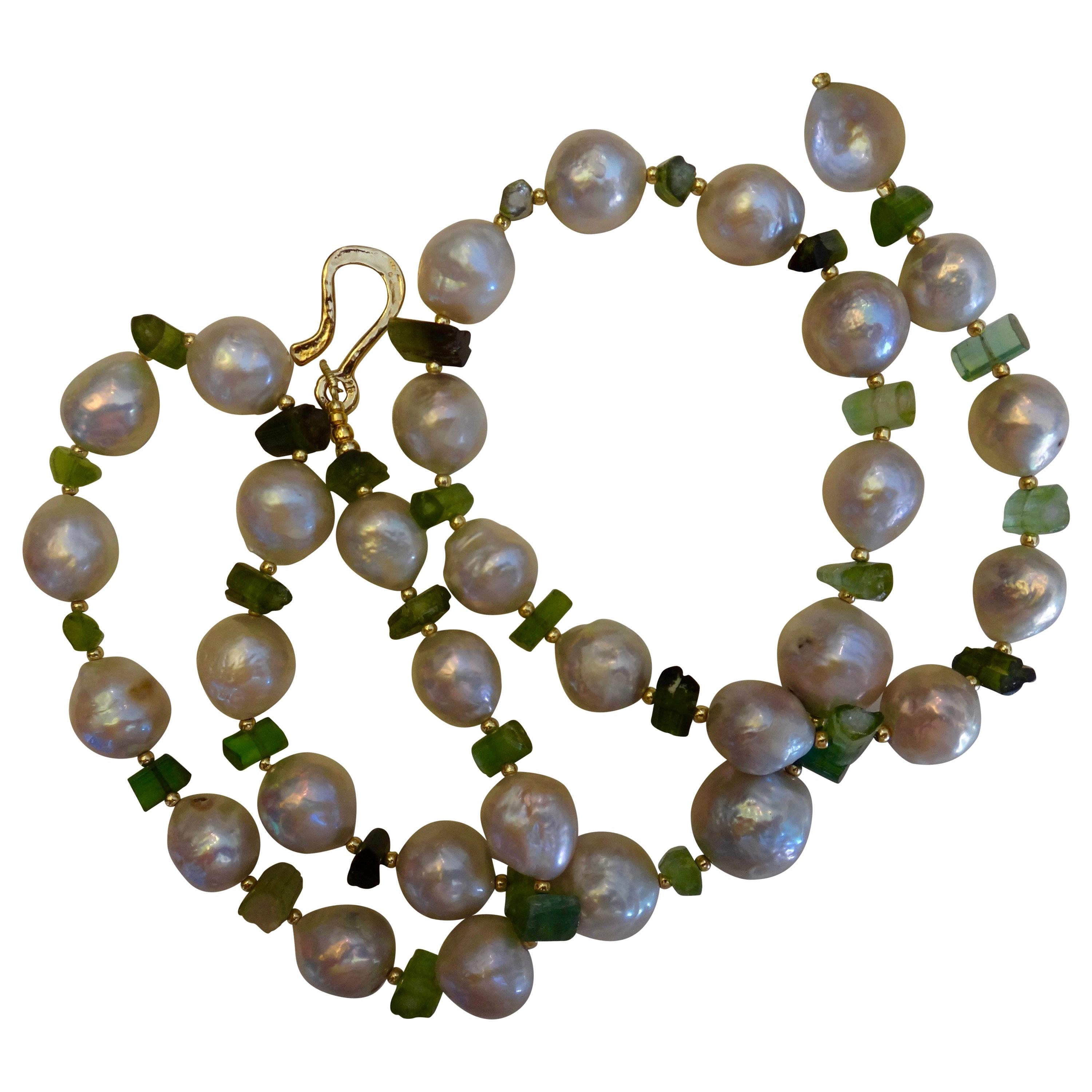 Kasumi pearls ( origin: Lake Kasumi, Japan) are renowned for their wonderful barque, wrinkly shapes and brilliant luster.  These white pearls are combined with raw tourmaline crystals in shades from light to dark green and tiny gold beads to create