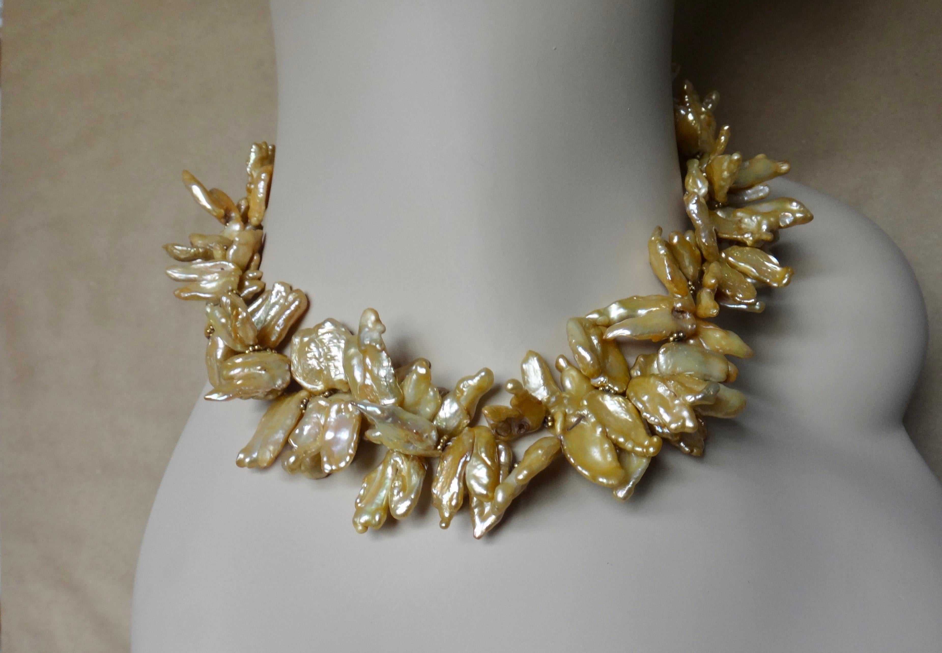 Two strands of highly baroque freshwater pearls in rich colors of khaki, tan and bronze are twisted together to create this stylish torsade necklace.  The unusually colored collection of pearls possess vivid luster and beautiful finish.  There are