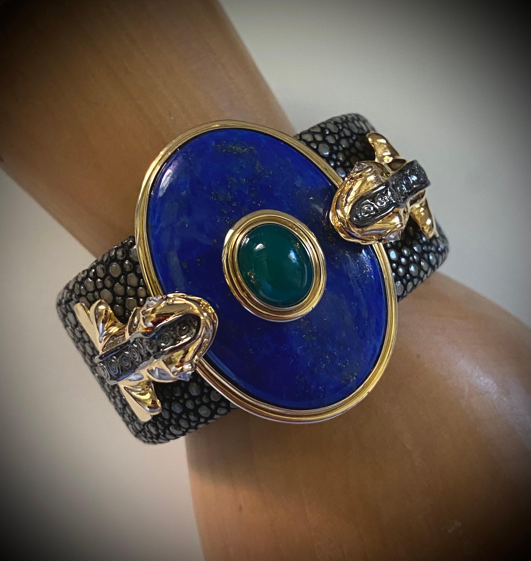 A huge lapis lazuli cabochon is mounted between two Inca Frogs in this spectacular cuff bracelet.  The lapis (origin: Peru) is brilliant blue in color with flecks of pyrite and is well polished  The frogs have reverse set diamond eyes and a black
