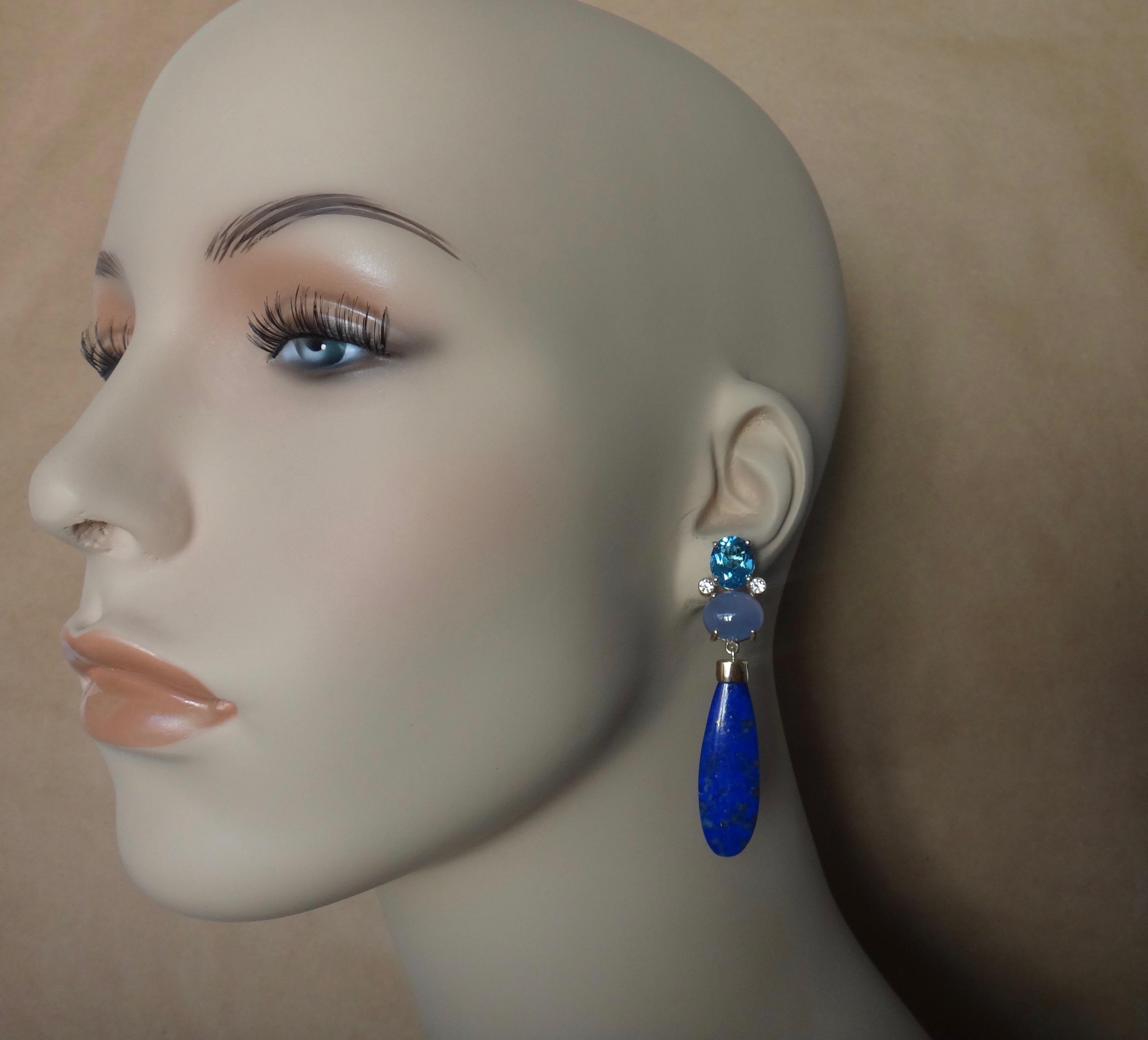 A palette of blues define these dramatic dangle earrings.  Oval cut, London blue topaz, brilliant cut white diamonds and cabochon blue chalcedony cluster together to form the tops.  Dangling below are are fantastic pair of Egyptian lapis lazuli. 