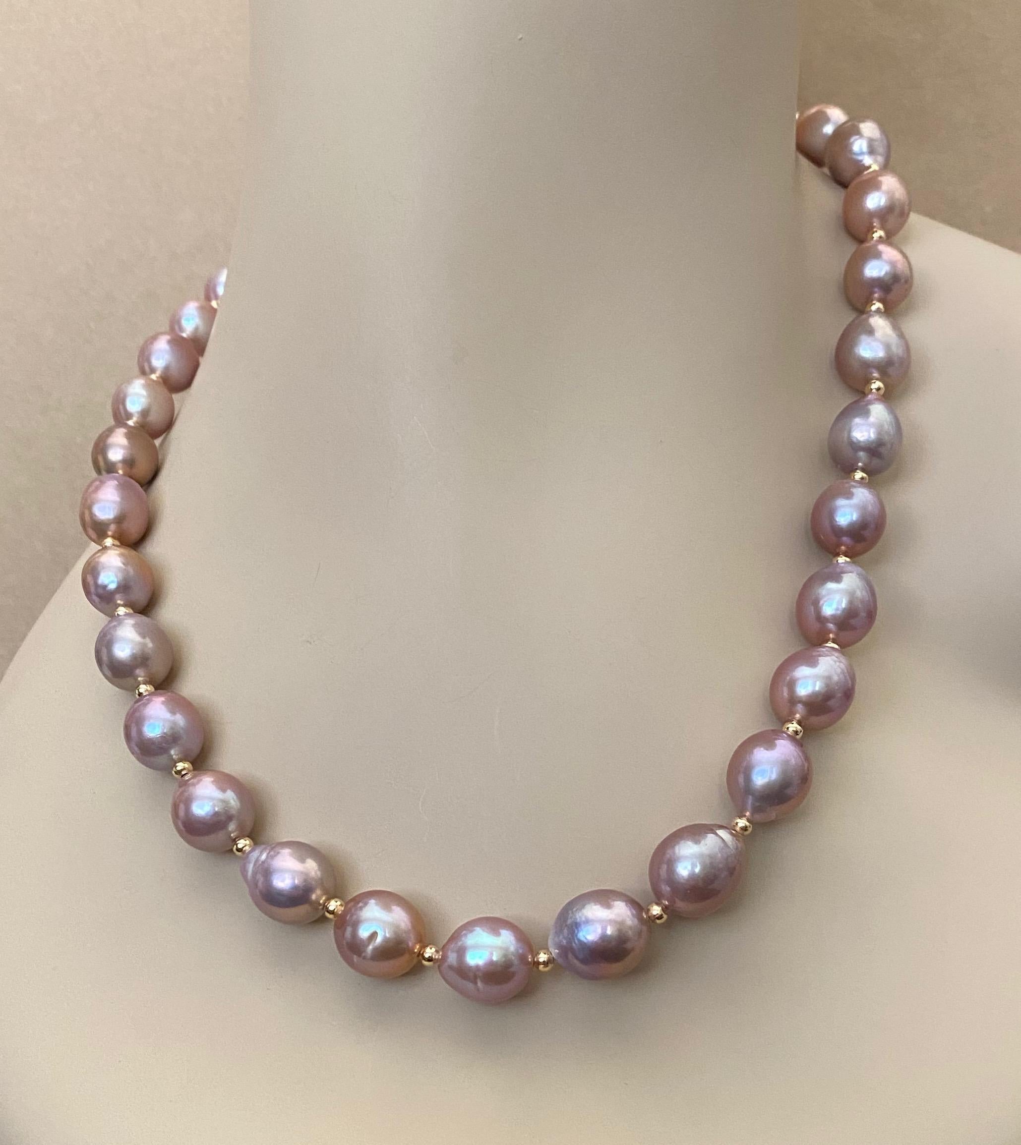Thirty one lavender baroque pearls form this striking necklace.  The pearls range in size from 11 mm to 15 mm at the center.  They are well matched, possess a glass-like luster and their nacre reflects golds and greens.  The pearls are spaced with