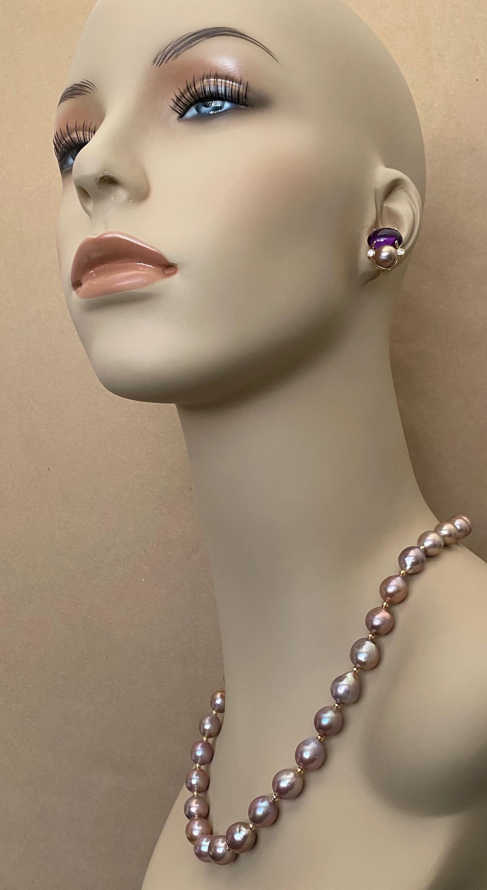 A strand of baroque lavender pearls are paired with cabochon amethyst, diamond and lavender pearl earrings in this eye catching suite of jewels.  Thirty one pearls form the necklace.  They possess rich luster and their nacre reflects golds and