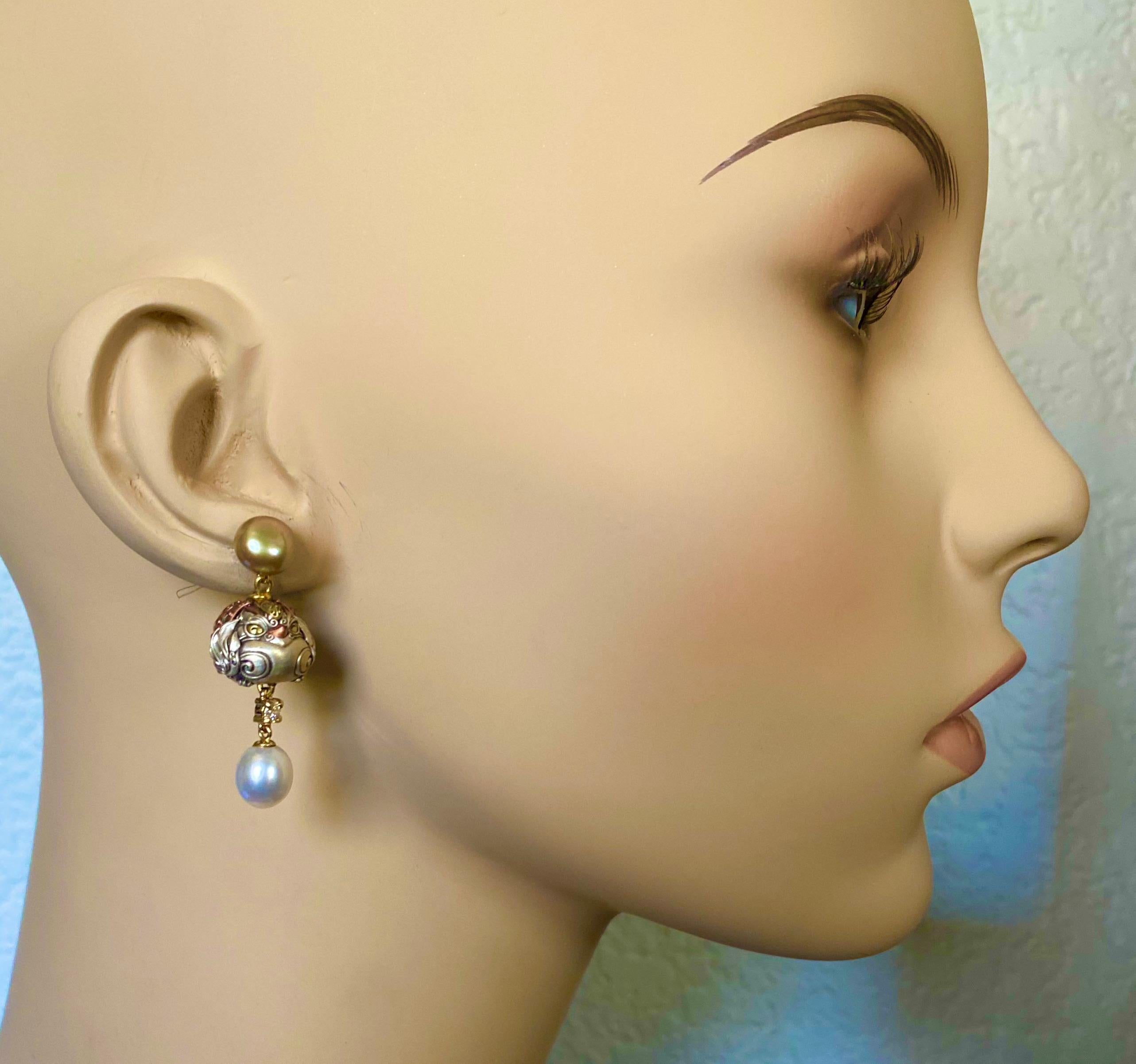 Mixed metal ojime beads are featured in these whimsical dangle earrings.  The beads come in the form of owls and are formed from silver, copper and gold.  They are complimented with white diamonds and white and gray pearls. These amusing earrings