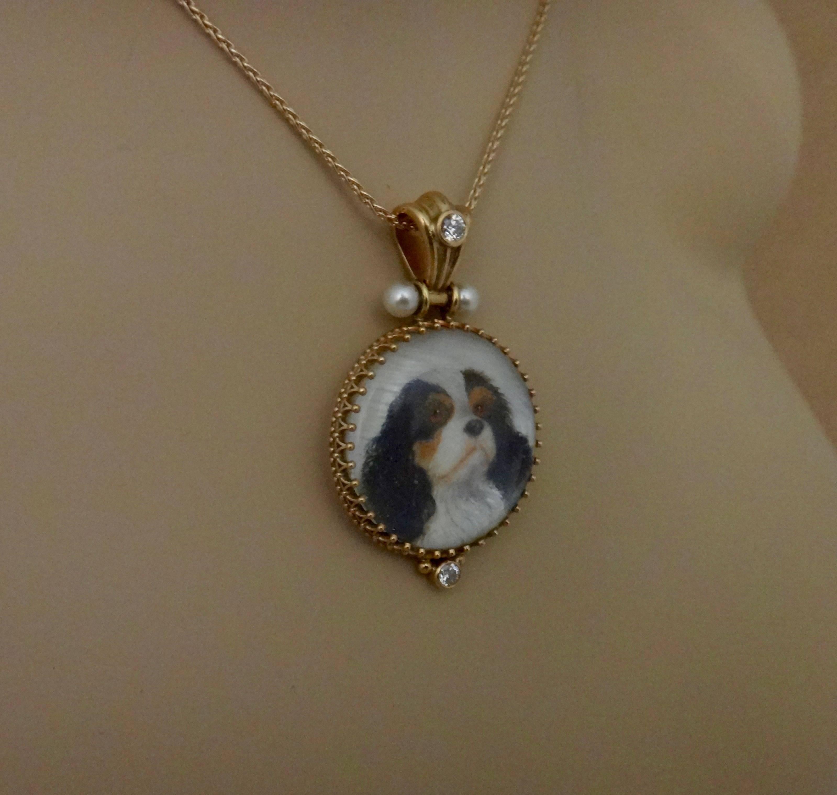 A miniature portrait of a King Charles Spaniel is featured in this one-of-a-kind pendant.  The oil on mother-of-pearl painting is by artist Georgina Love.  The painting is protected by a rock crystal lenses and is set in a filigree frame decorated