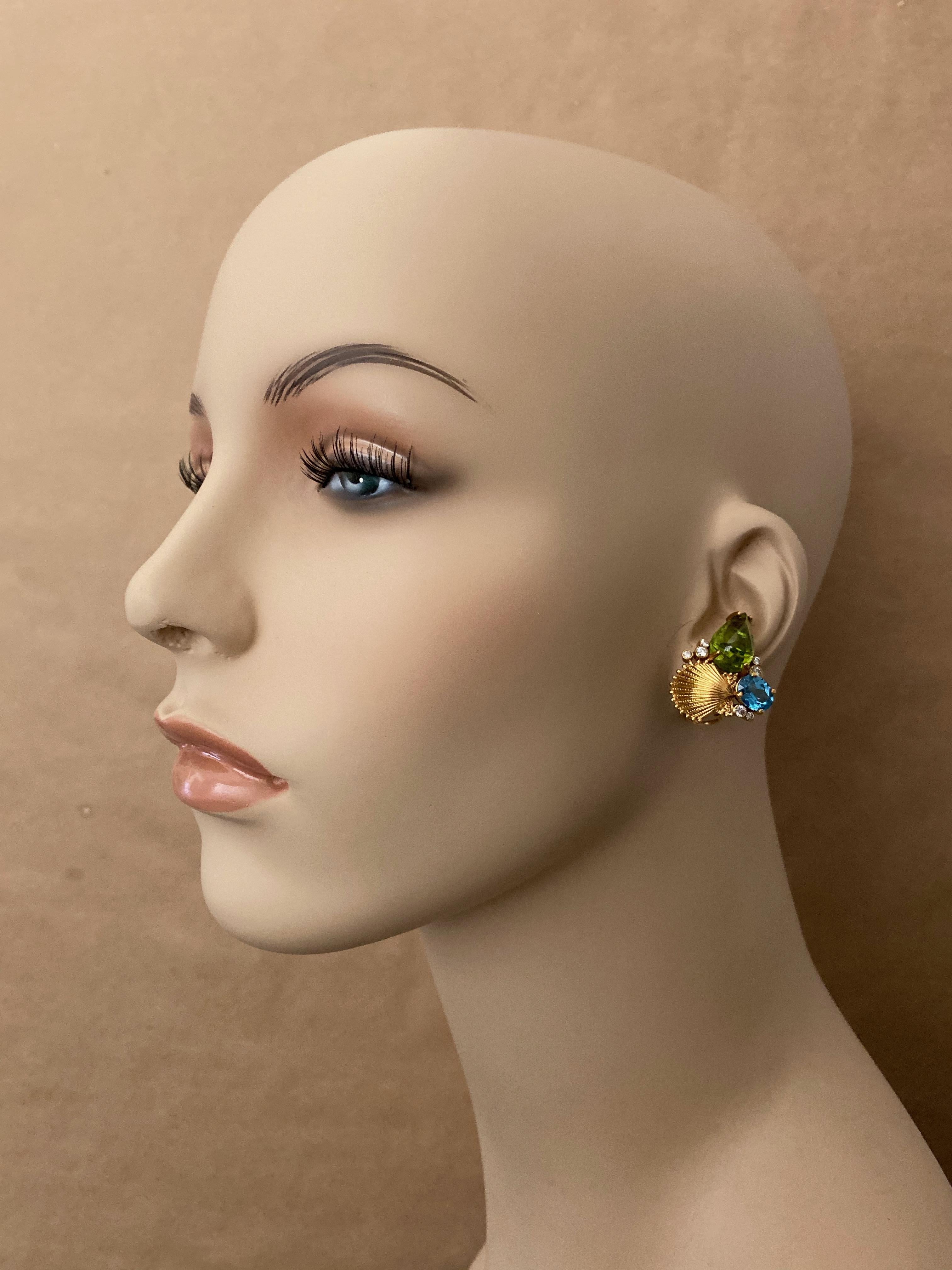 A fine and highly unusual pair cabochon peridot (origin: Pakistan) are featured in these sea life inspired earrings.  The pear shaped gems were cut in Germany, are the classic peridot color with 