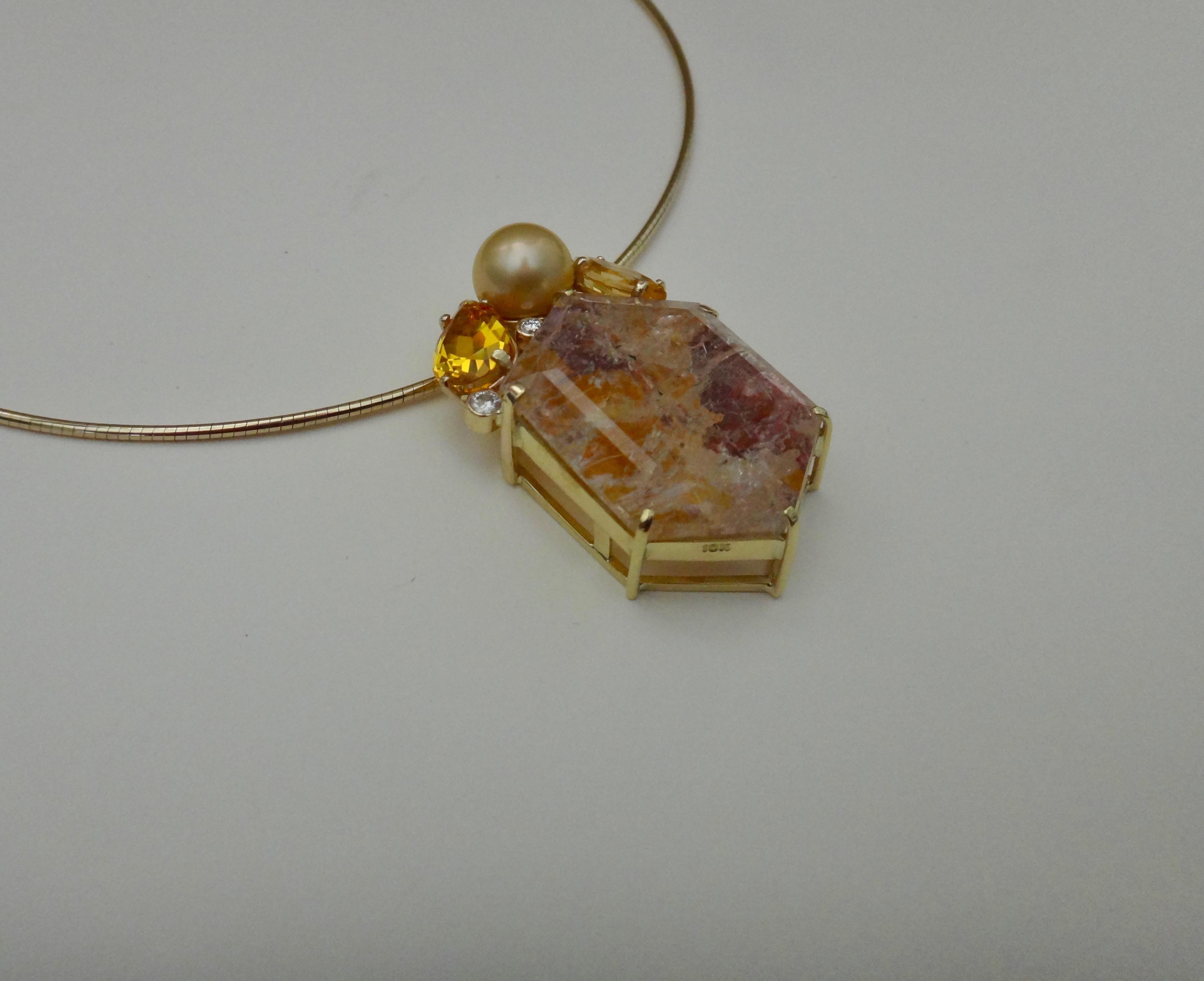 A boldly configured hexagon shaped phantom quartz is the centerpiece of this confetti pendant.  Pale shades of rust and gold are due to iron oxide trapped within the clear quartz.  Those colors are complimented by pear shaped and marquise shaped