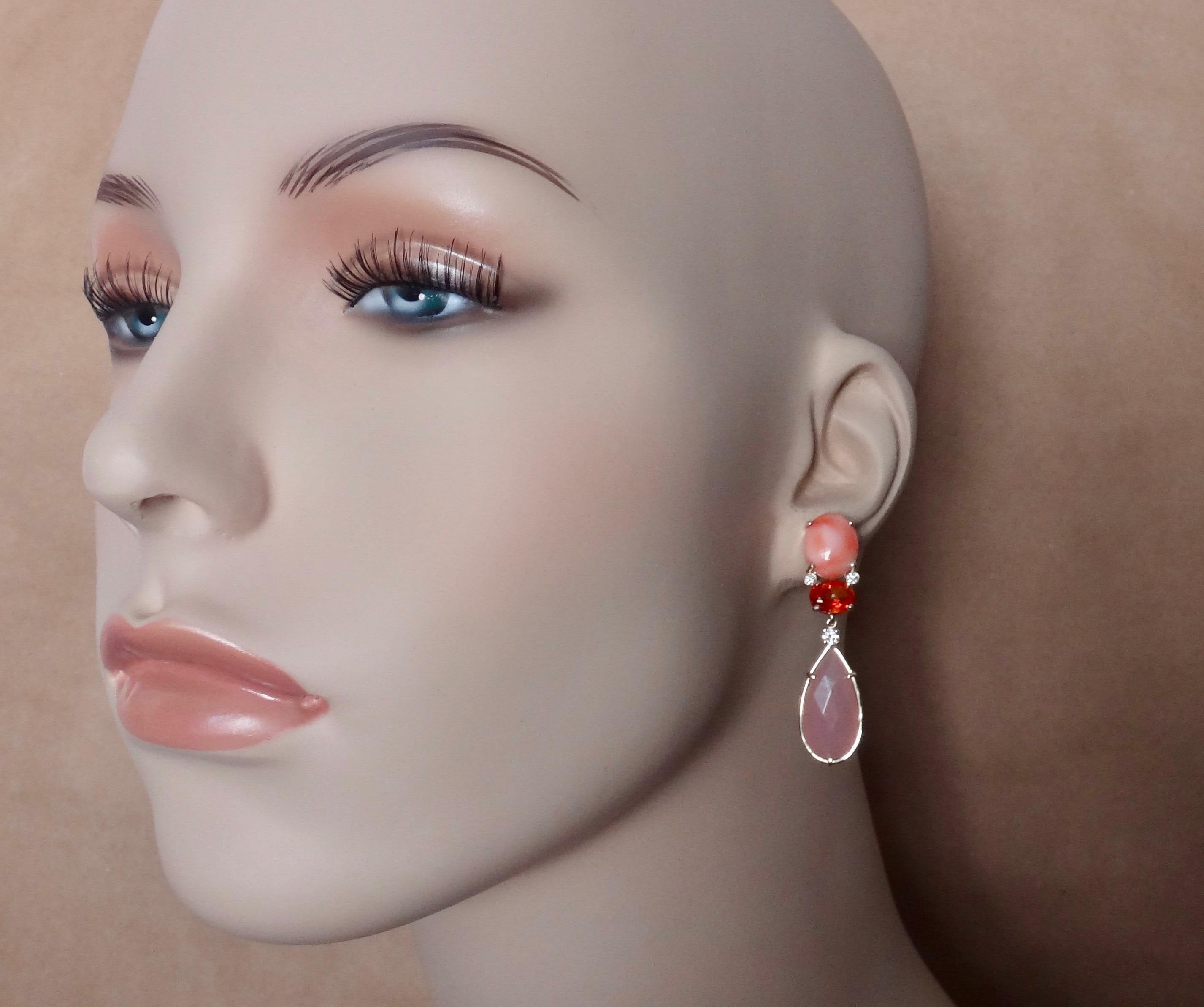 Coral (origin: Japan) is combined with intensely colored orange fire opal (origin: Mexico) and pink opal (origin: Peru) in these delicate dangle earrings.  This sophisticated palette beautifully highlights the modeled pink coral with the lighter
