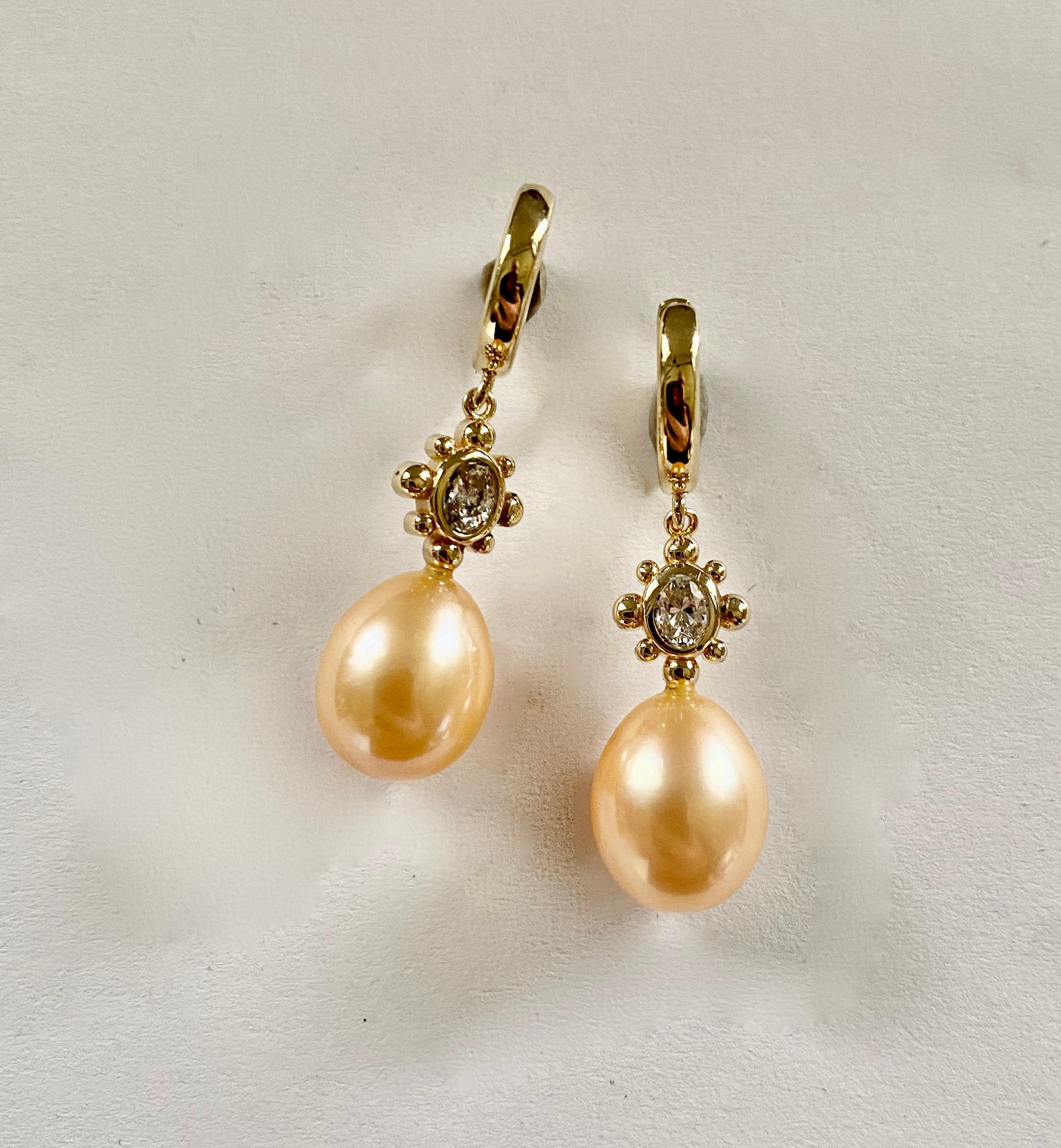 Bei diesen zierlichen Ohrringen sind rosa Perlen mit ovalen Diamanten gepaart.  Die Perlen sind birnenförmig und in einem zarten Muschelrosa gehalten. Sie sind frei von Fehlern und besitzen einen schönen Glanz.  Der Entwurf für diese Ohrringe wurde