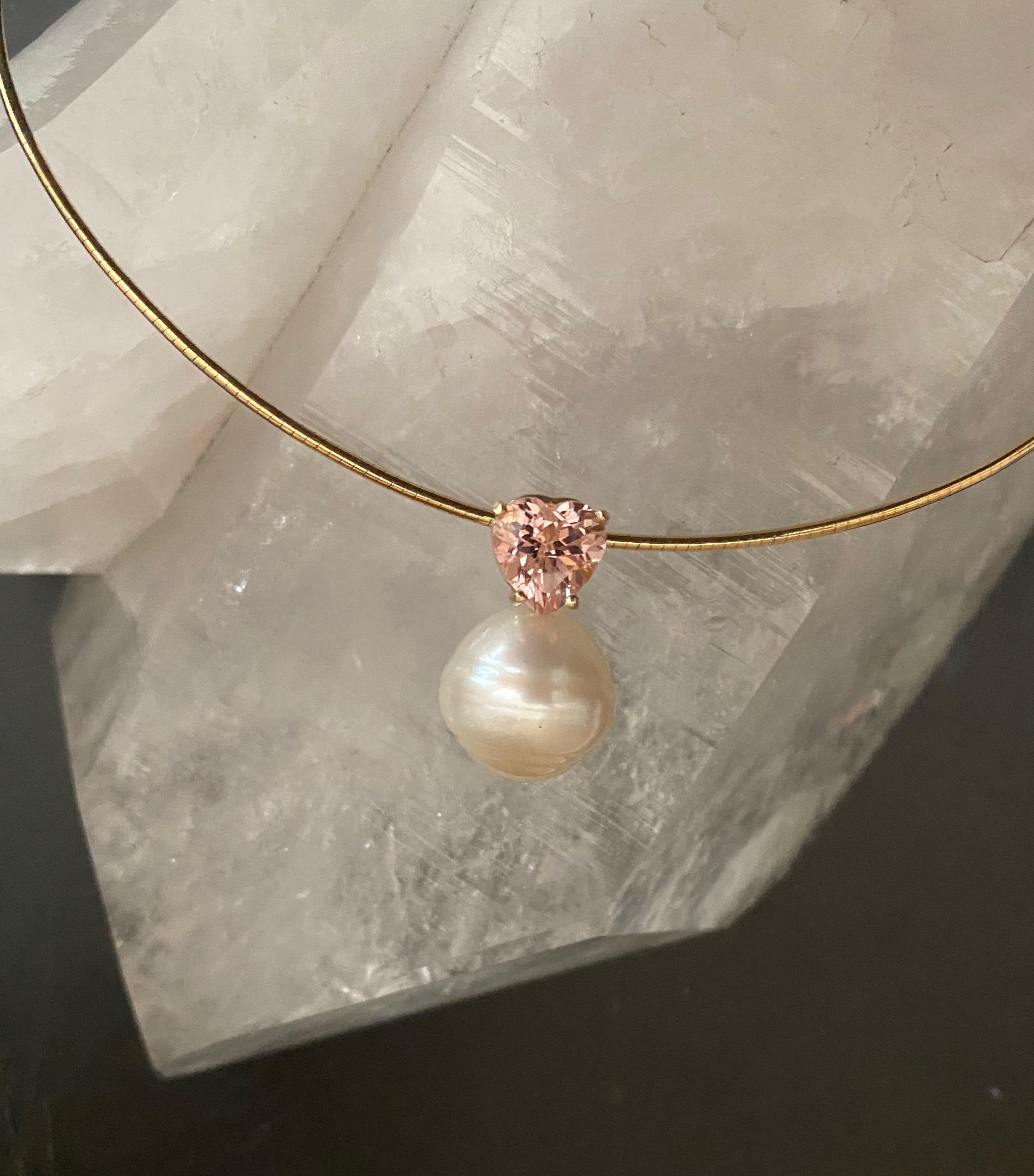 A heart shaped pink tourmaline (origin: Namibia) is paired with a Paspaley South Seas pearl (origin: Australia) in this tres chic pendant.  The tourmaline is a wonderful shell pink color, flawless and is beautifully cut and polished.  The pearl is a