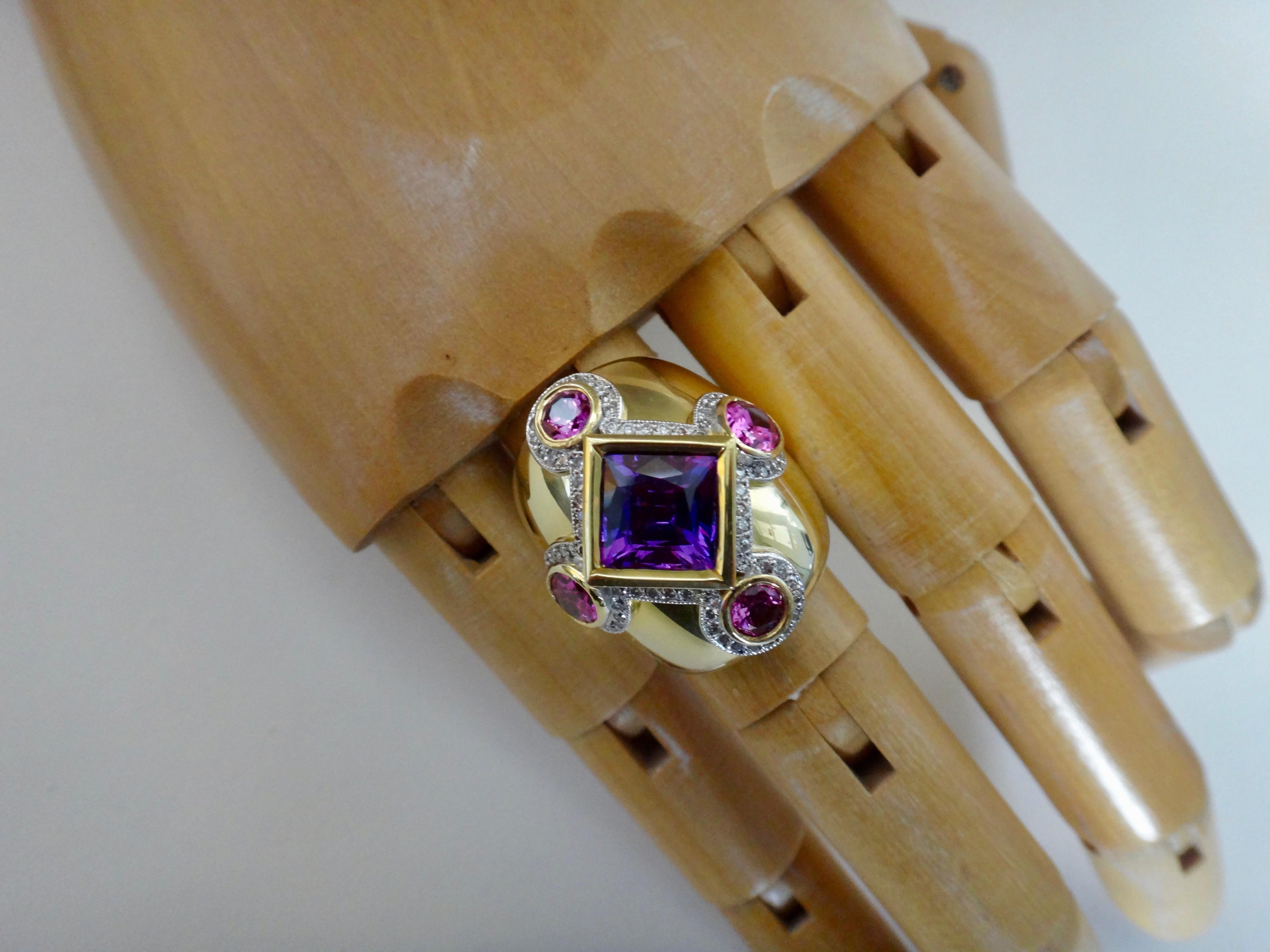 A square cut purple spinel is flanked by round and oval cut pink spinels (origin: Sri Lanka) in this one-of-a-kind 18k yellow gold dome ring.  Highlighting the five intensely colored gems is a frame of pave set, brilliant cut white diamonds.  The