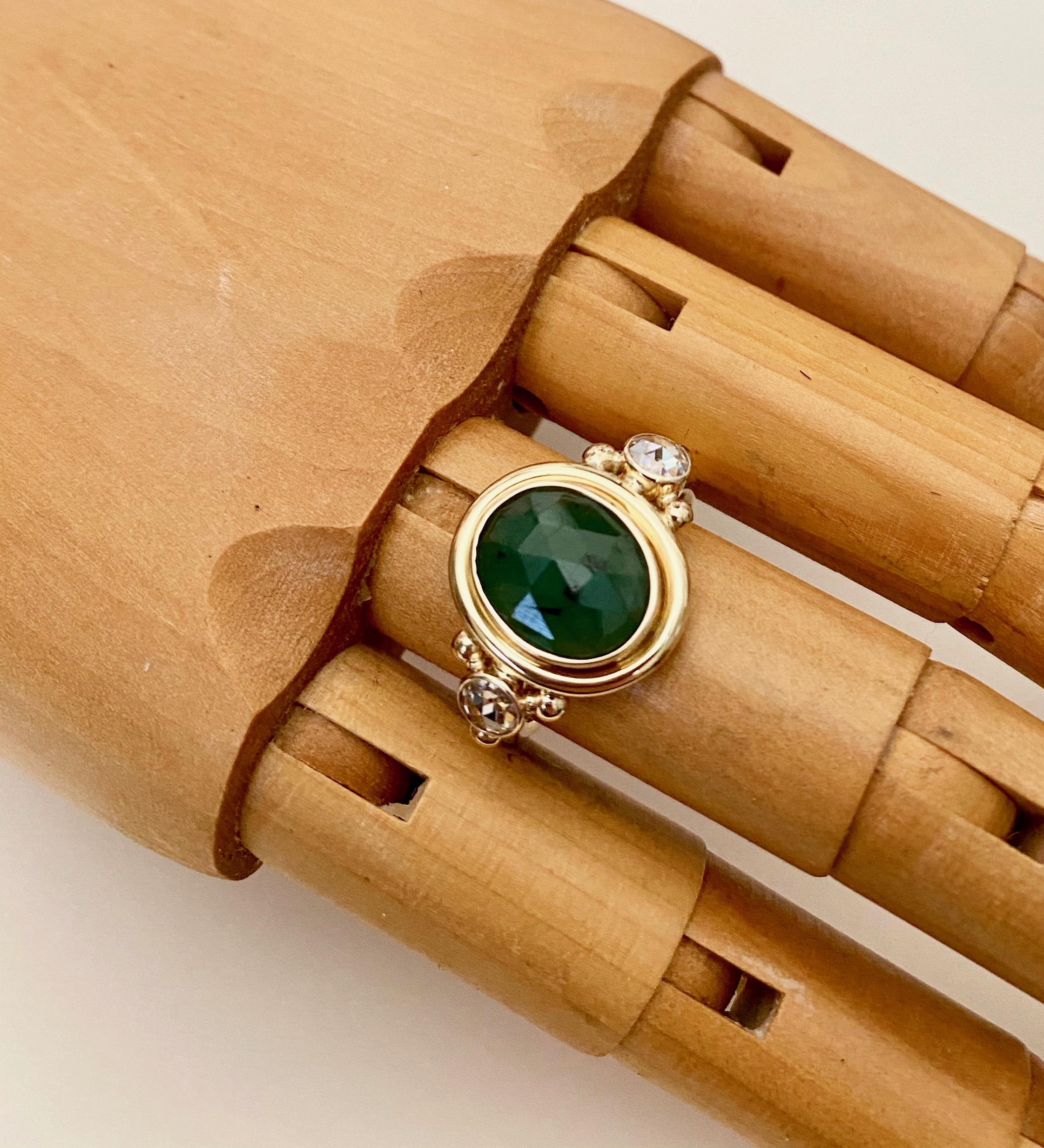 A rose cut emerald (origin: Brazil) is featured in this one-of-a-kind, archaic style cocktail ring.  The oval cut emerald is a rich 