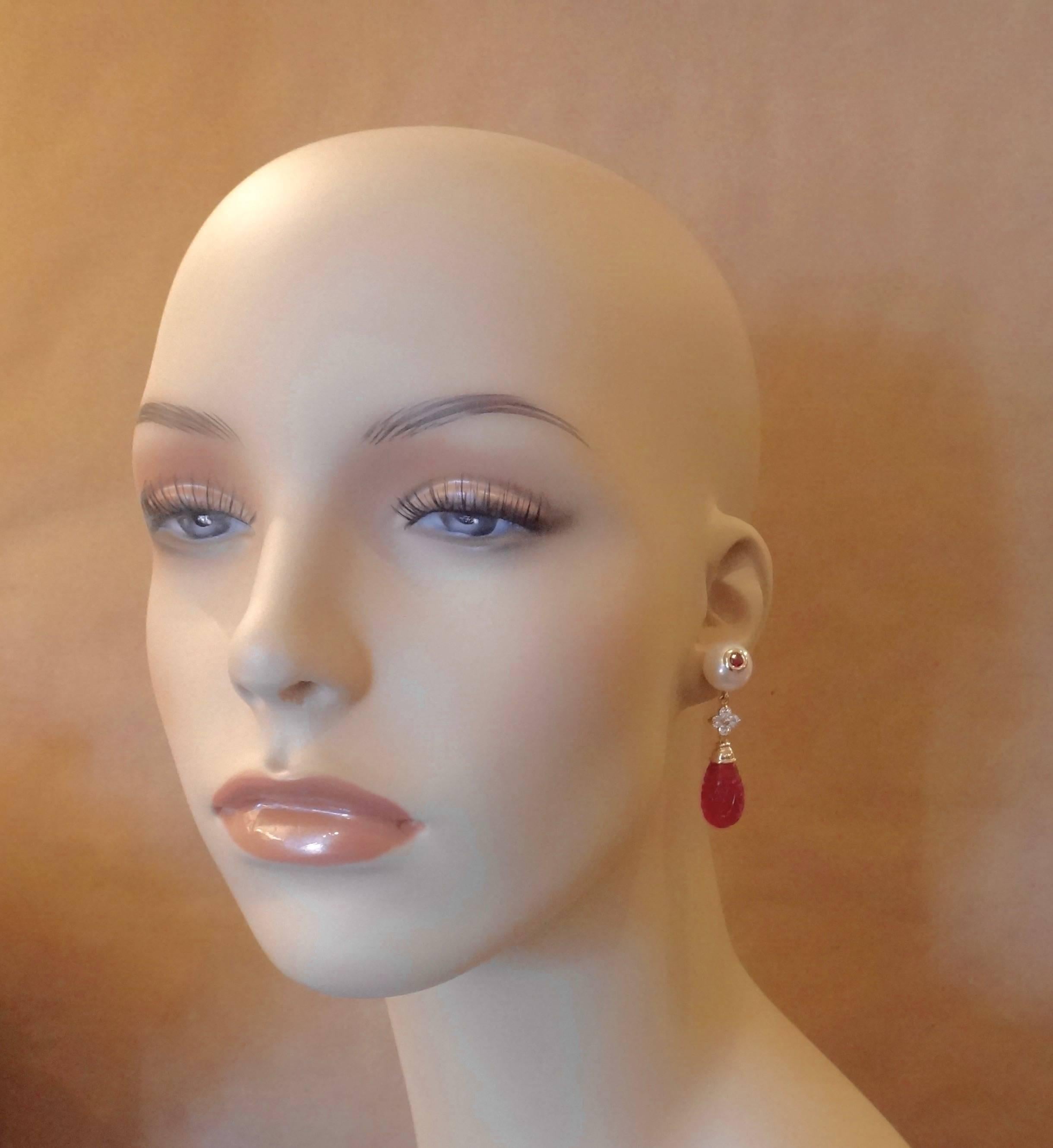 A brilliant pair of rubelites (red tourmaline) are bezel set into white cultured pearls in these quintessential dangle earrings.  Further additions to this composition are white diamonds and a pair of intricately carved red topaz drops.  All set in