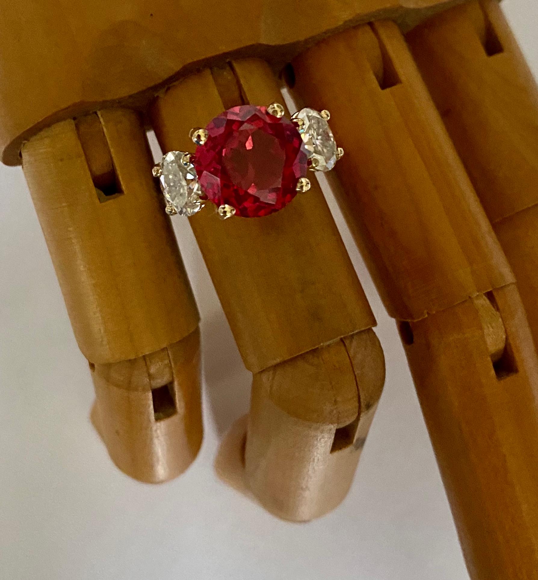 Rubellite is the featured gem in this elegant three stone ring.  Rubellite (origin: Brazil) is the red form of the larger family of tourmaline gemstones.  Tourmaline is a durable and very wearable gem.  This rubellite is bright red and fashioned