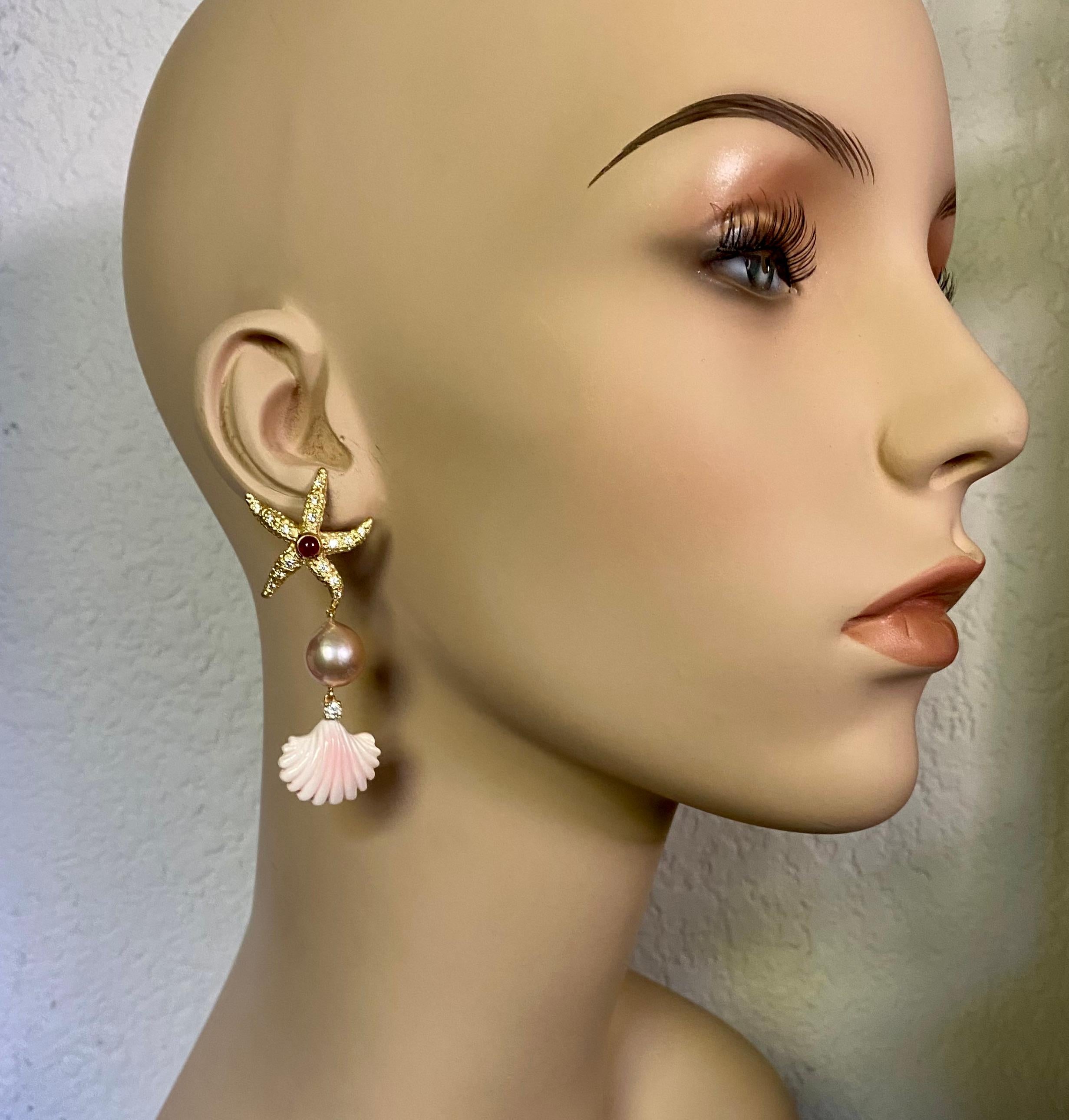 Rubini, diamanti, perle e conchiglie intagliate si uniscono per formare questi esotici e stravaganti orecchini pendenti.  I rubini cabochon sono incastonati nella stella marina.  Le gemme sono sapientemente tagliate e lucidate.  Le braccia della