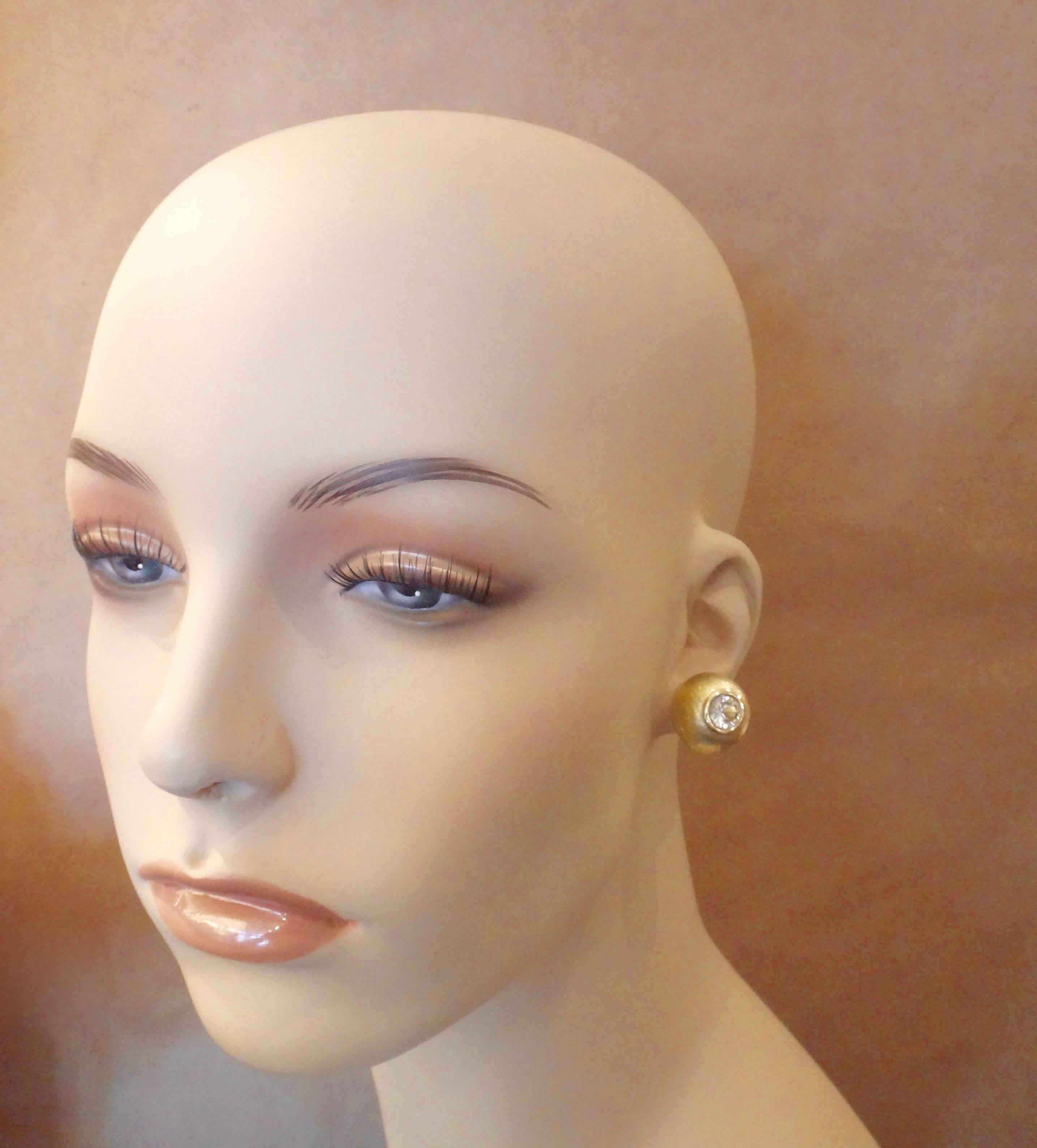 Brilliant cut Silver Sapphires are bezel set in these classic style button earrings.  The hammered 18k yellow gold, high profile domes are a rich satin finish while the bezels are high polished.  These earrings are a great compliment to Michael