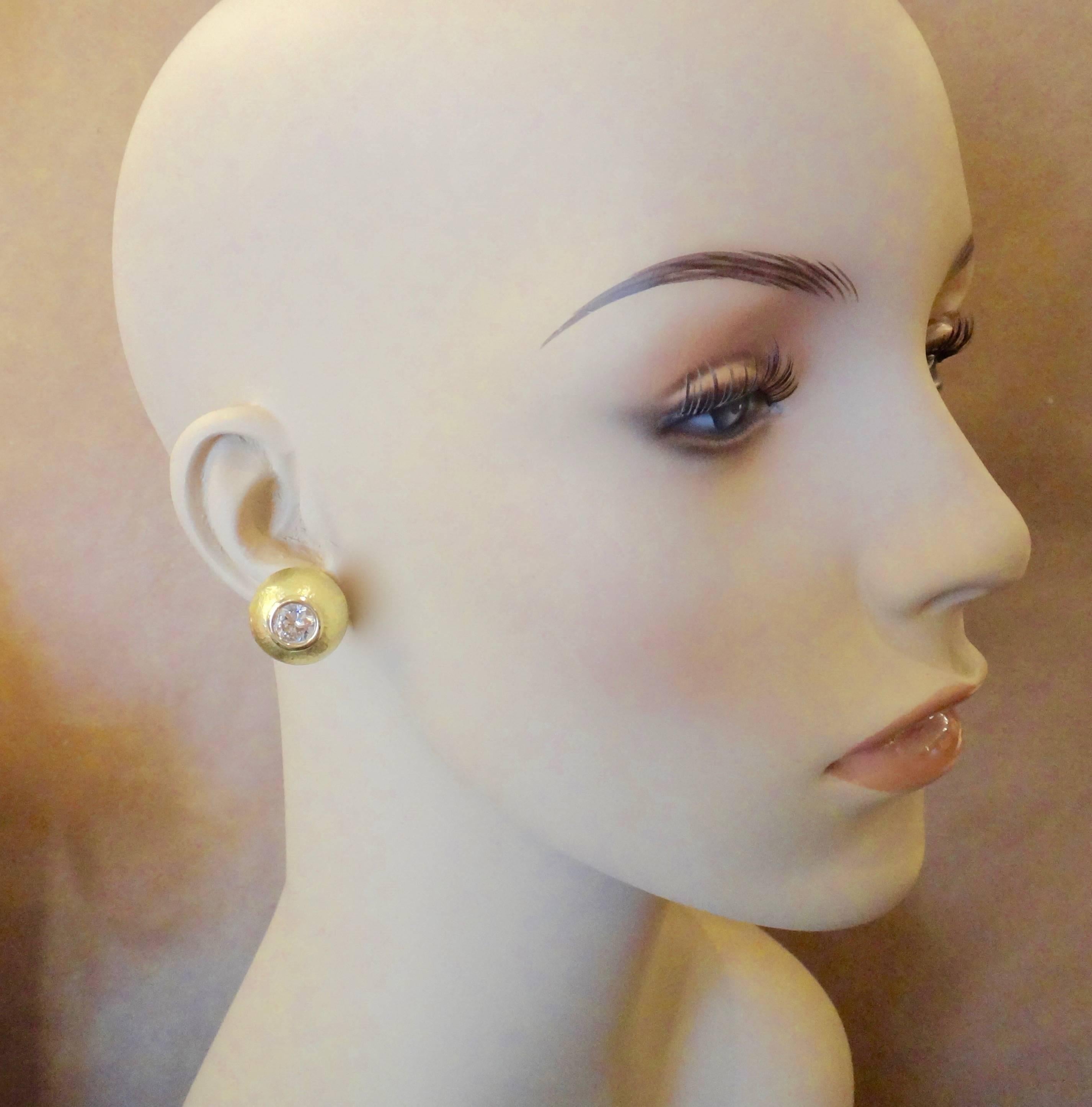 Brilliant cut Silver Sapphires are bezel set in these classic button earrings.  The hammered 18k yellow gold, high profile domes are a rich satin finish while the bezels are high polished.  They are a great compliment to Michael Kneebone's 24k and