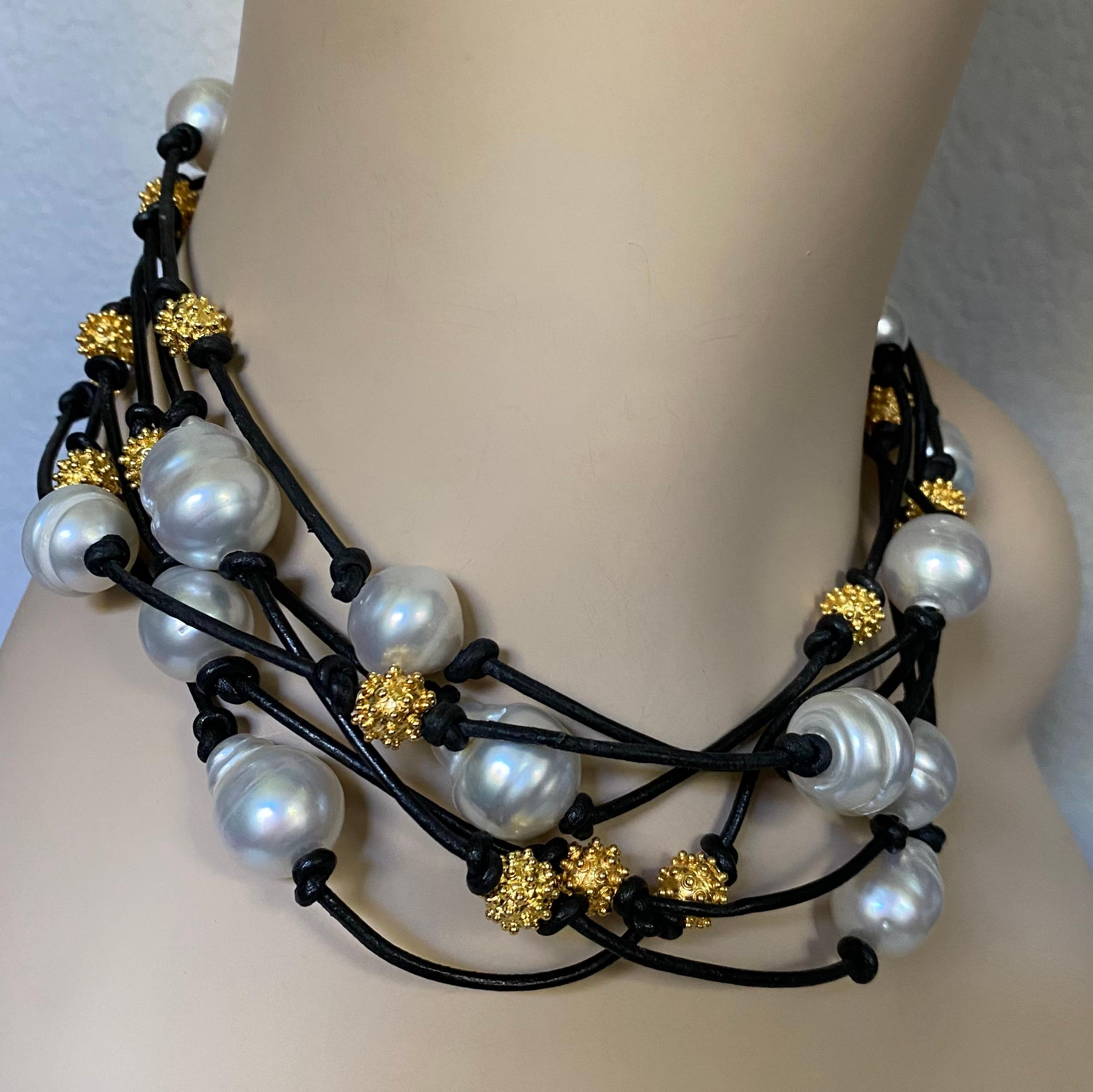 Baroque South Seas pearls are paired with granulated beads in this bold torsade necklace.  The pearls are bright white with irregularities typically found in baroque pearls of all types.  They have been drilled, strung and knotted on a black leather