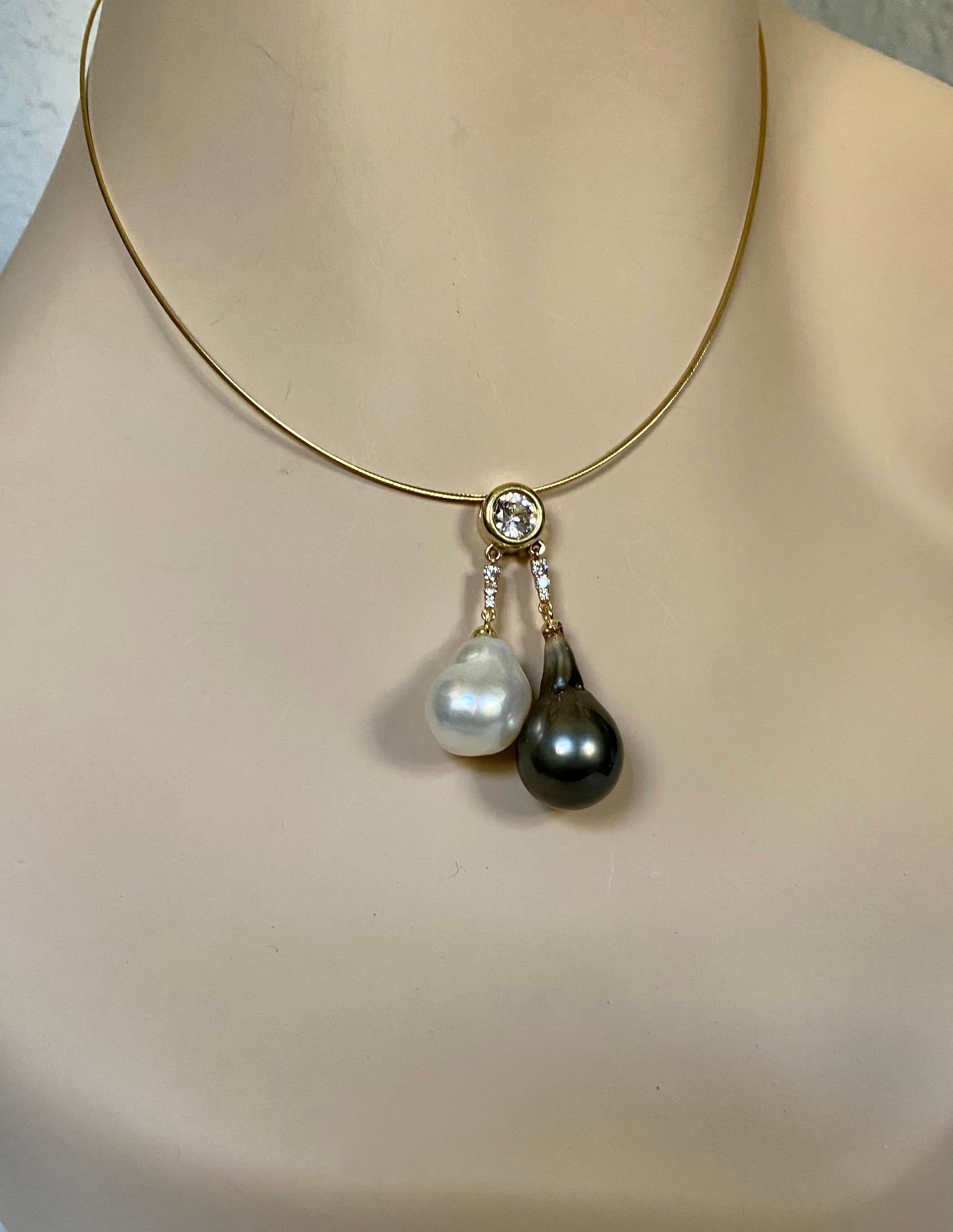 Baroque pearls are featured in this unique drop pendant.  The South Seas pearl is sourced from Paspaley, the largest cultivator of pearls in Australia.  The black pearl is from Tahiti.  Both pearls have rich luster and  though baroque, have blemish