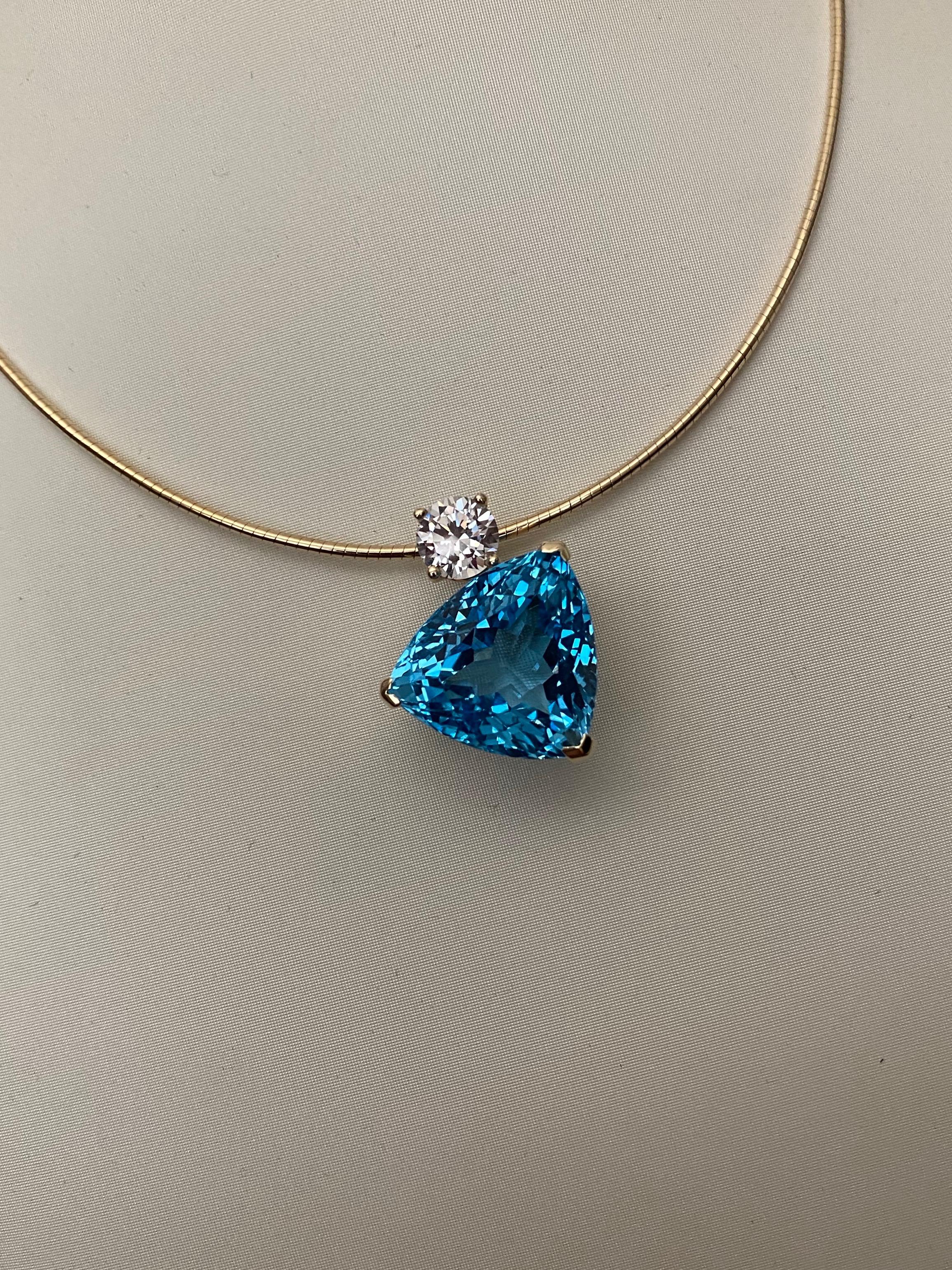 A trillion shaped Swiss blue topaz (origin: Thailand) is featured in this asymmetrical pendant.  The topaz weighs 43.18 carats. There are a multitude of tiny, diamond shaped facets placed in what is know as a Portuguese configuration.  The gem is a