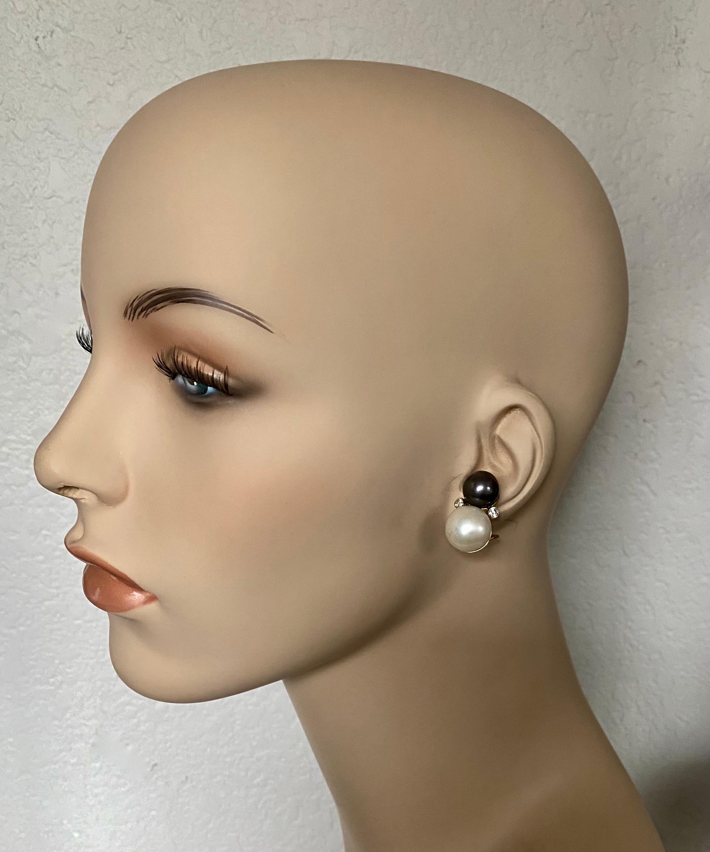 Black and white pearls characterize these elegant button style earrings.  The 11mm Tahitian pearls are richly colored with great luster.  The 14mm South Seas button pearls are pure white in color with blemish free surfaces.  Complimenting the pearls